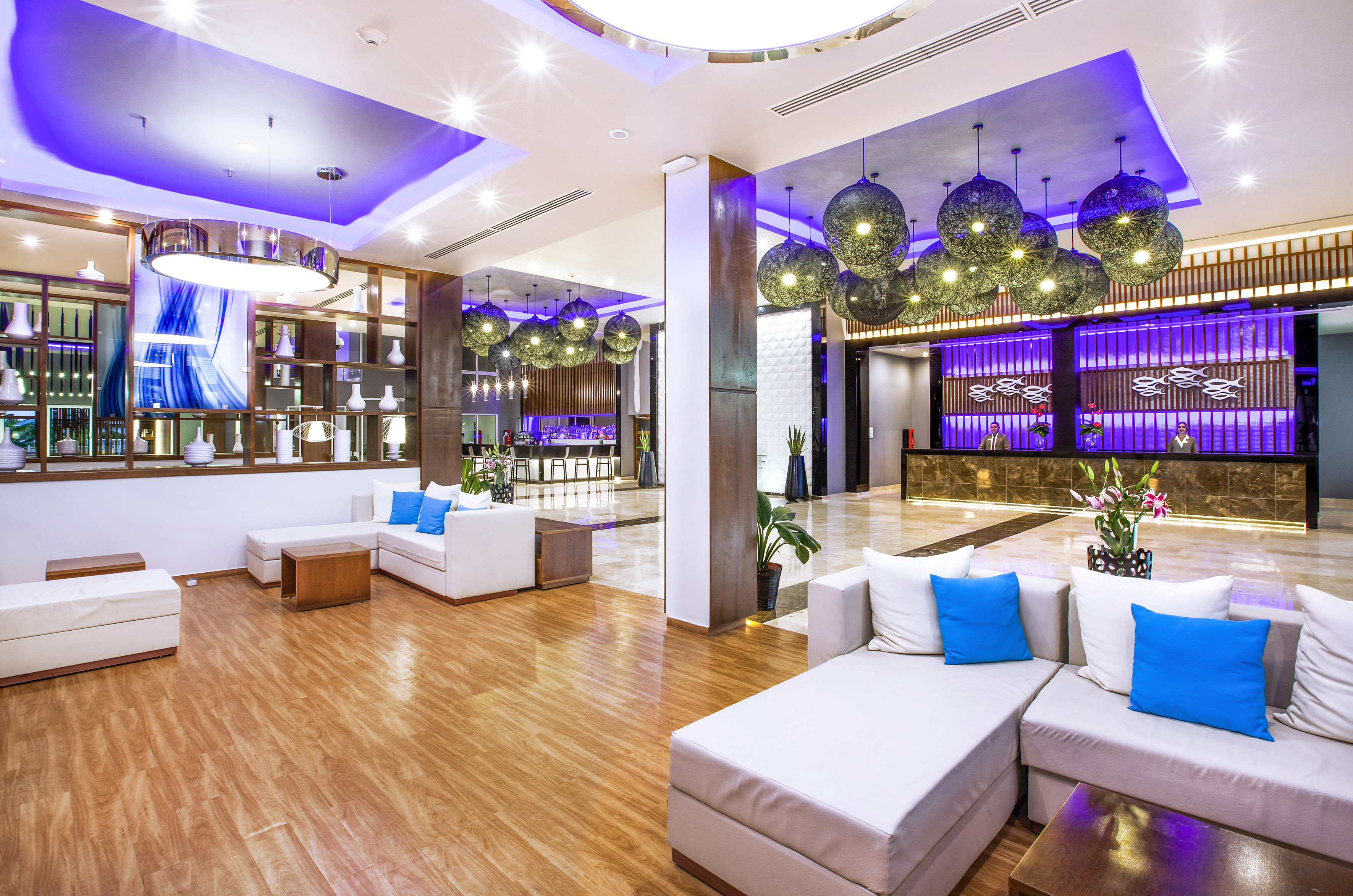 a lobby with white couches and blue and purple lights