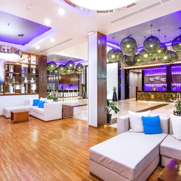 a lobby with white couches and blue and purple lights