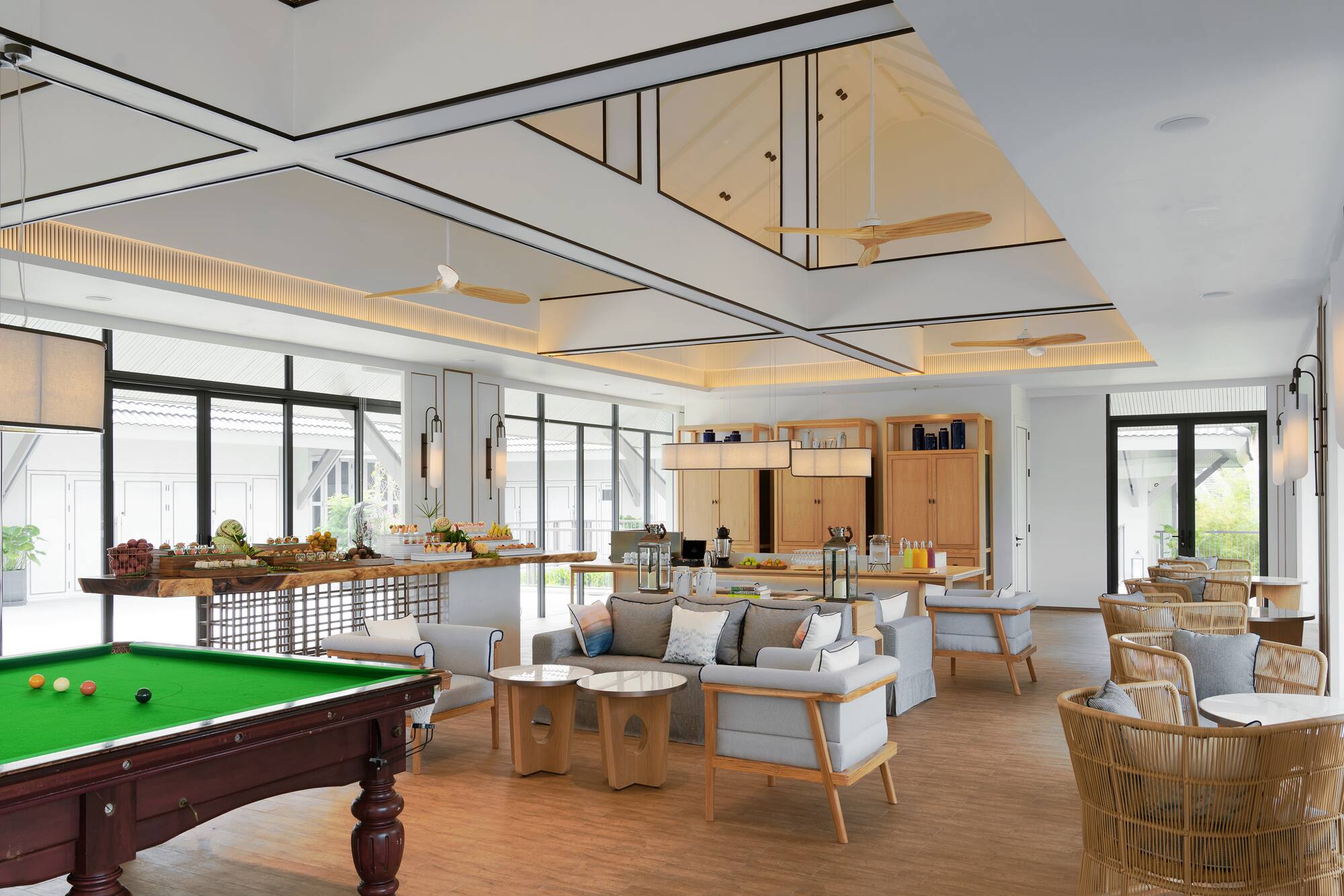 Modern resort lounge with billiards table, lounge seating, and buffet area.