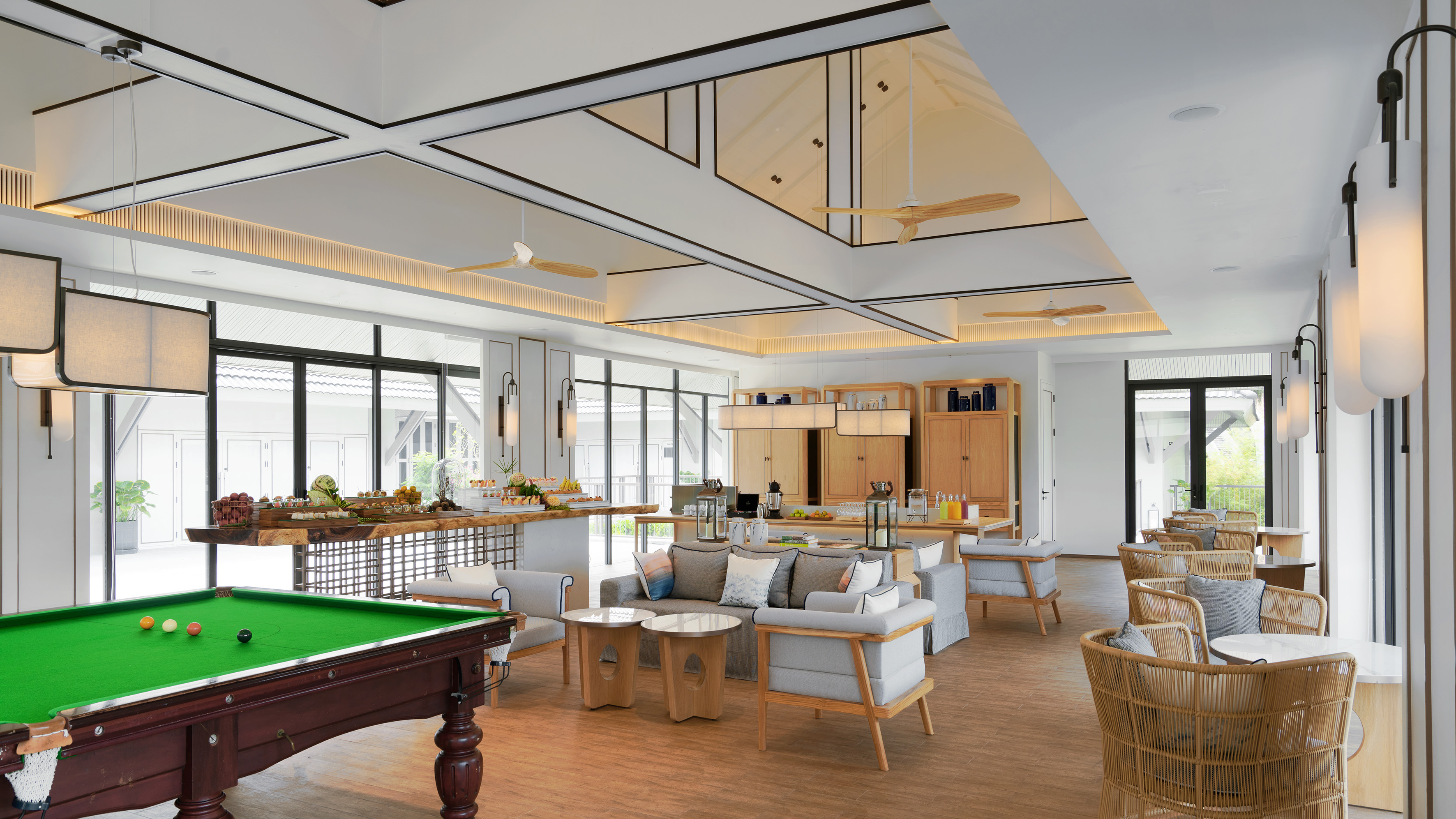 Modern resort lounge with billiards table, lounge seating, and buffet area.