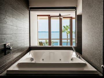 a bathtub with a window overlooking the ocean