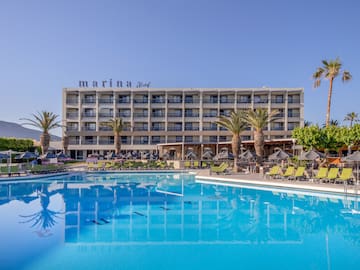 a swimming pool with palm trees and a building