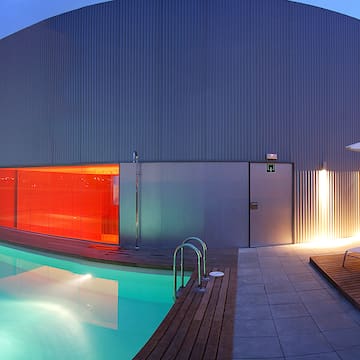 a pool with a red glass wall