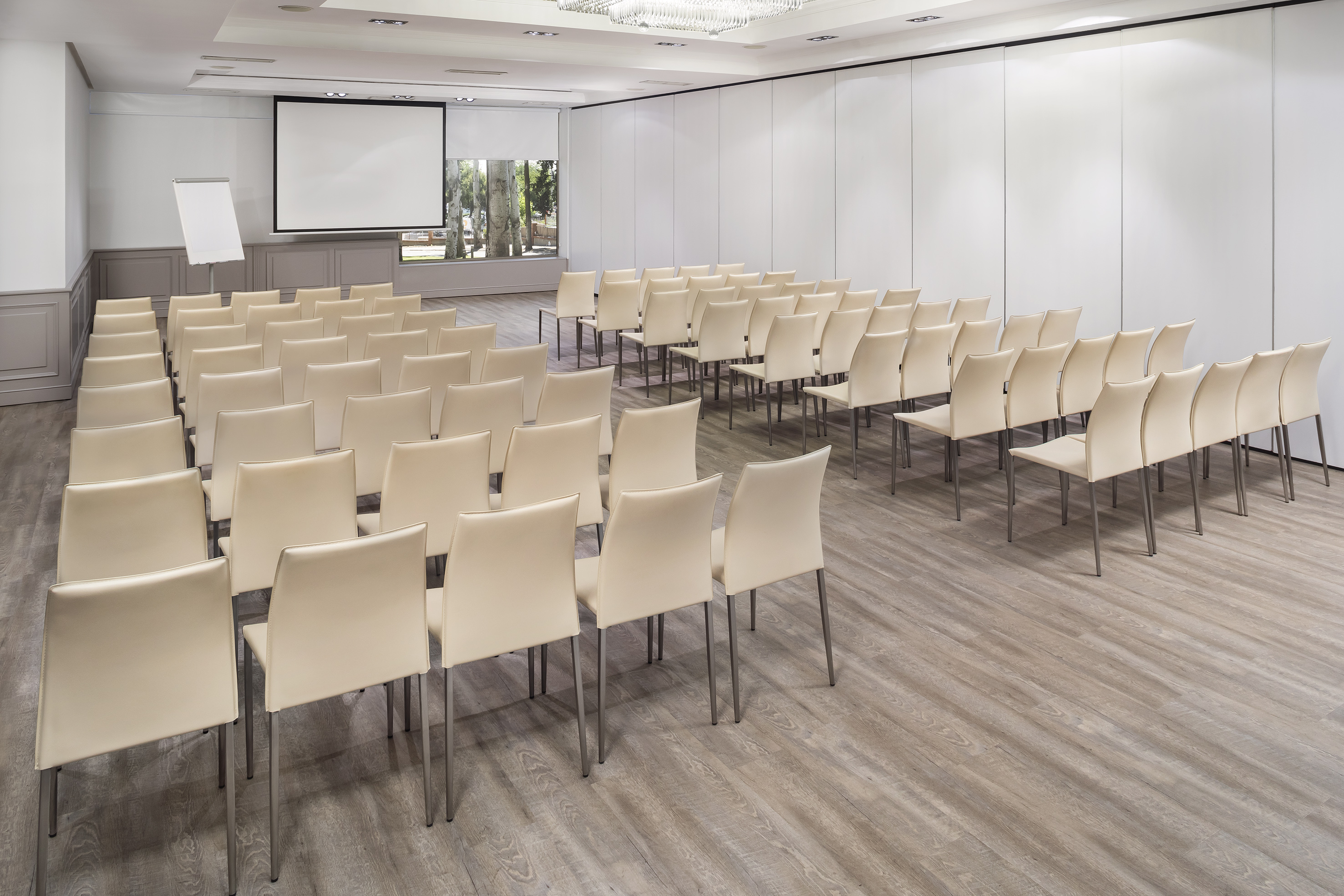 a room with white chairs and a projector screen