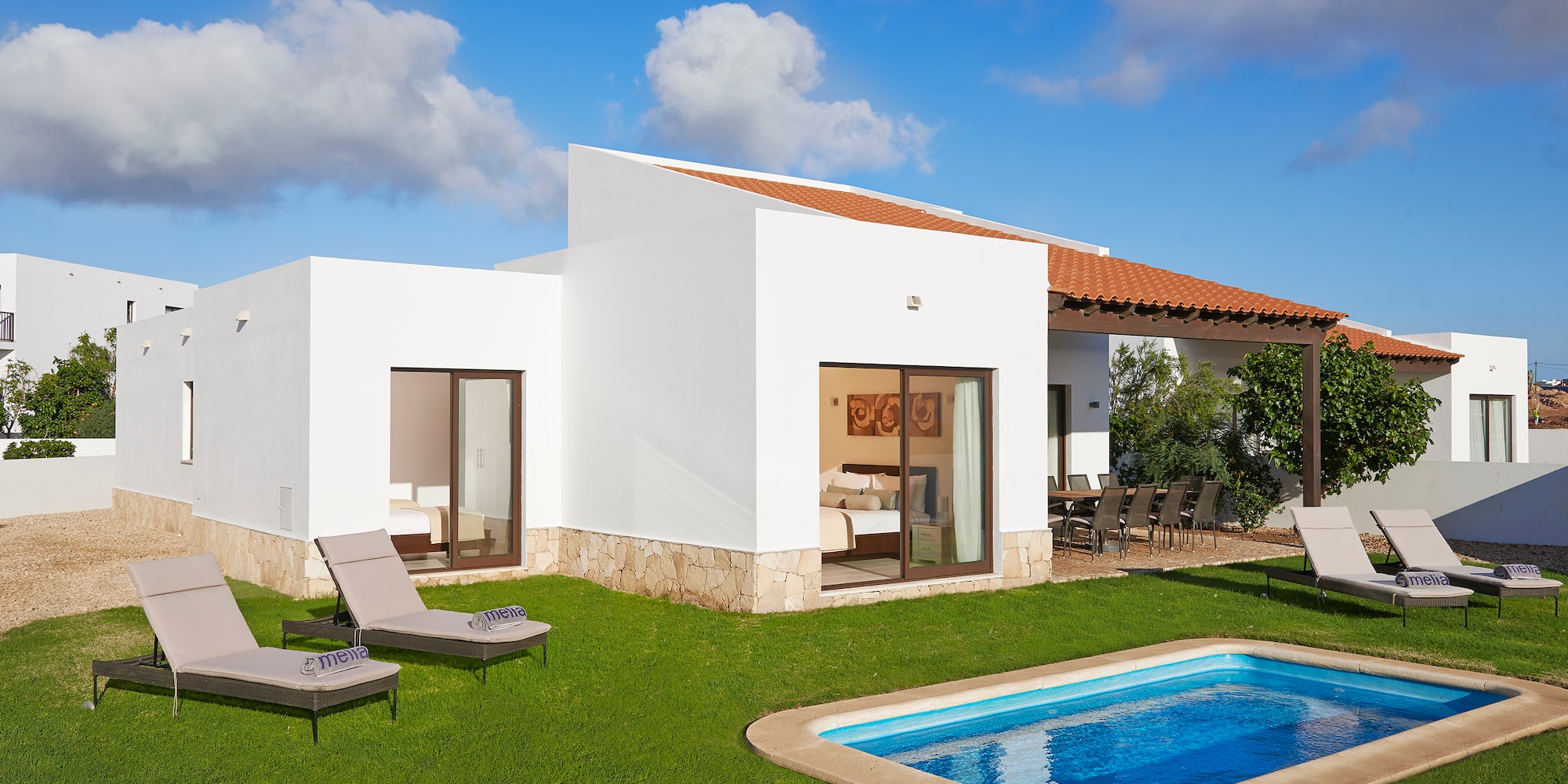 a pool in the grass next to a house