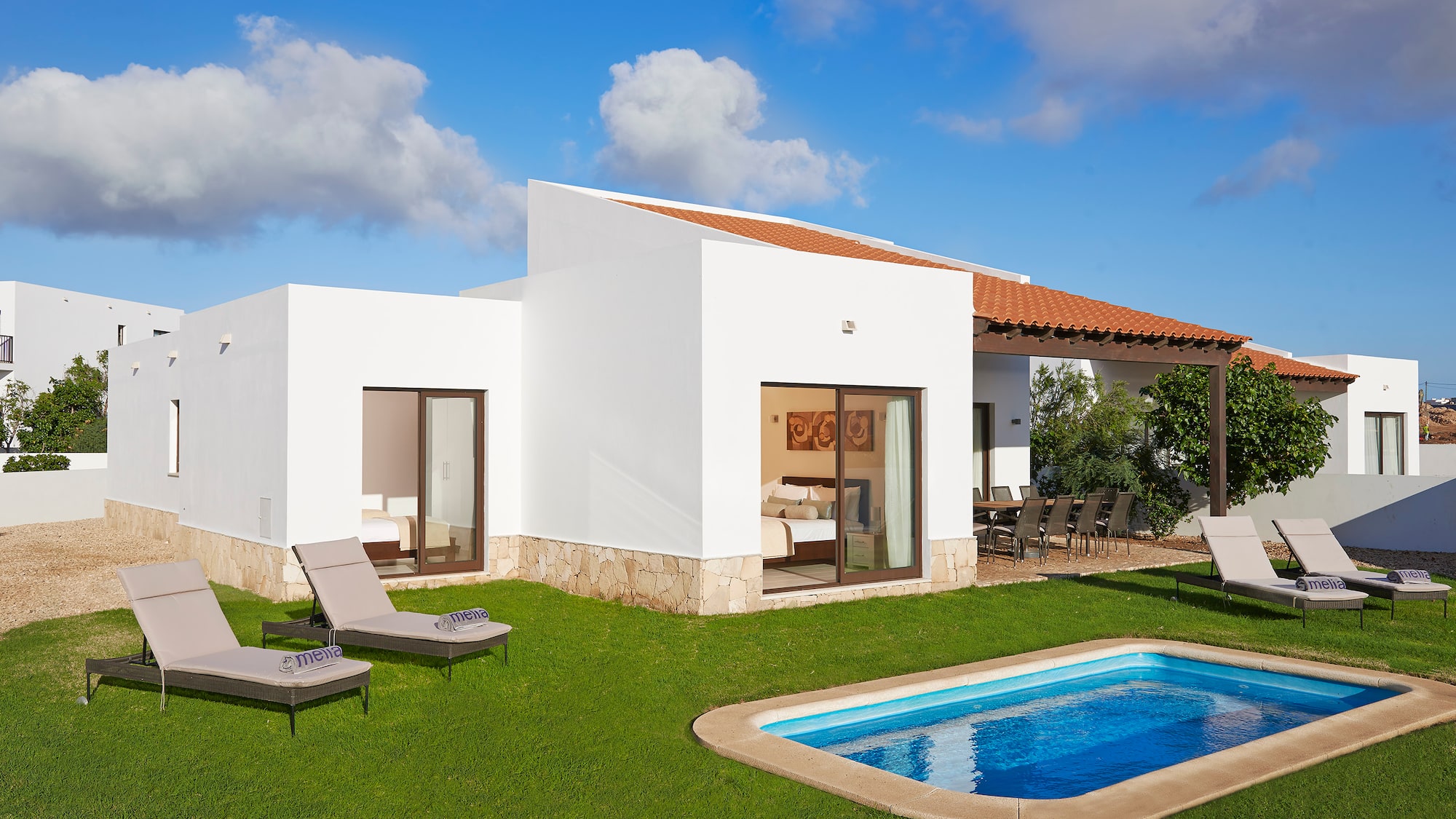 a pool in the grass next to a house
