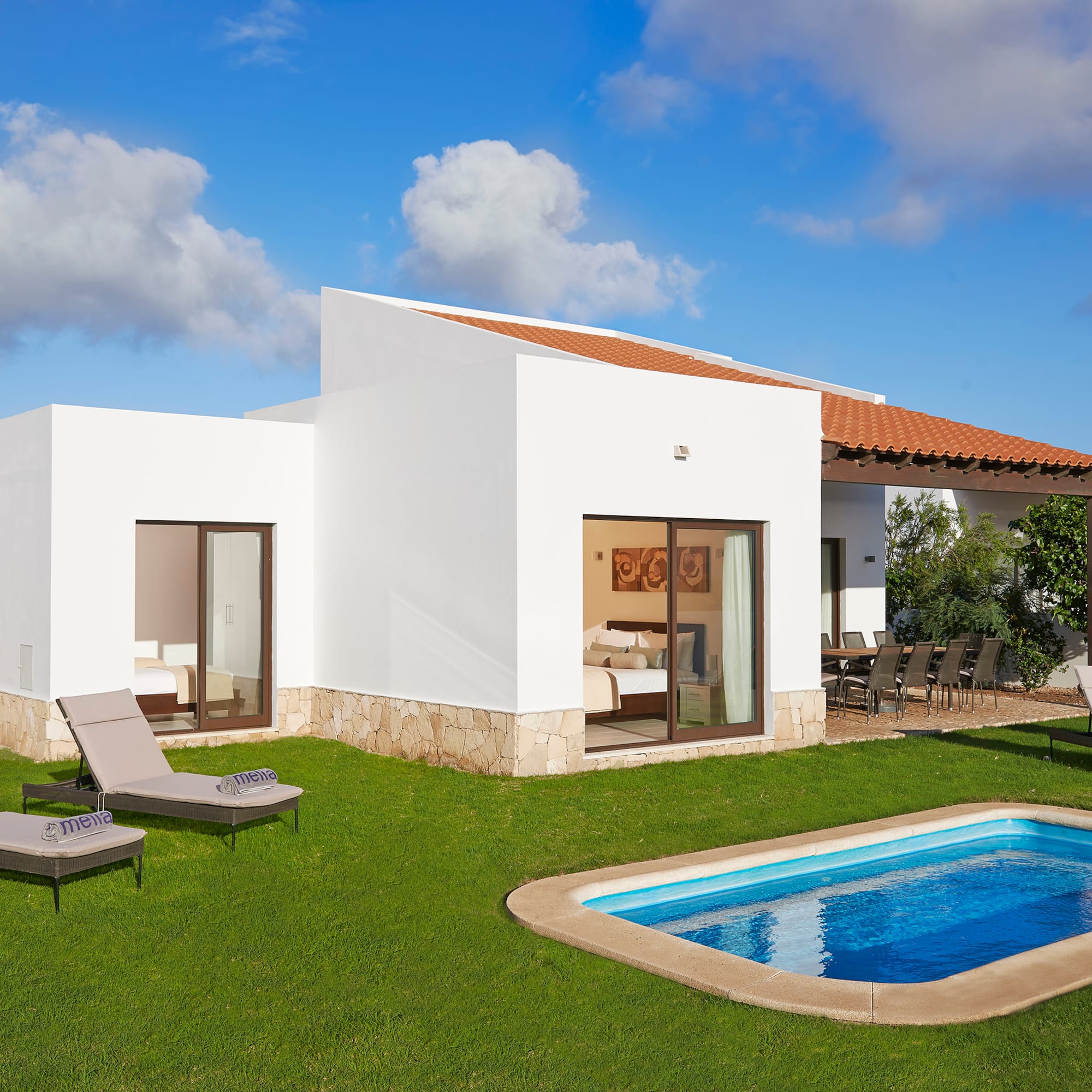 a pool in the grass next to a house