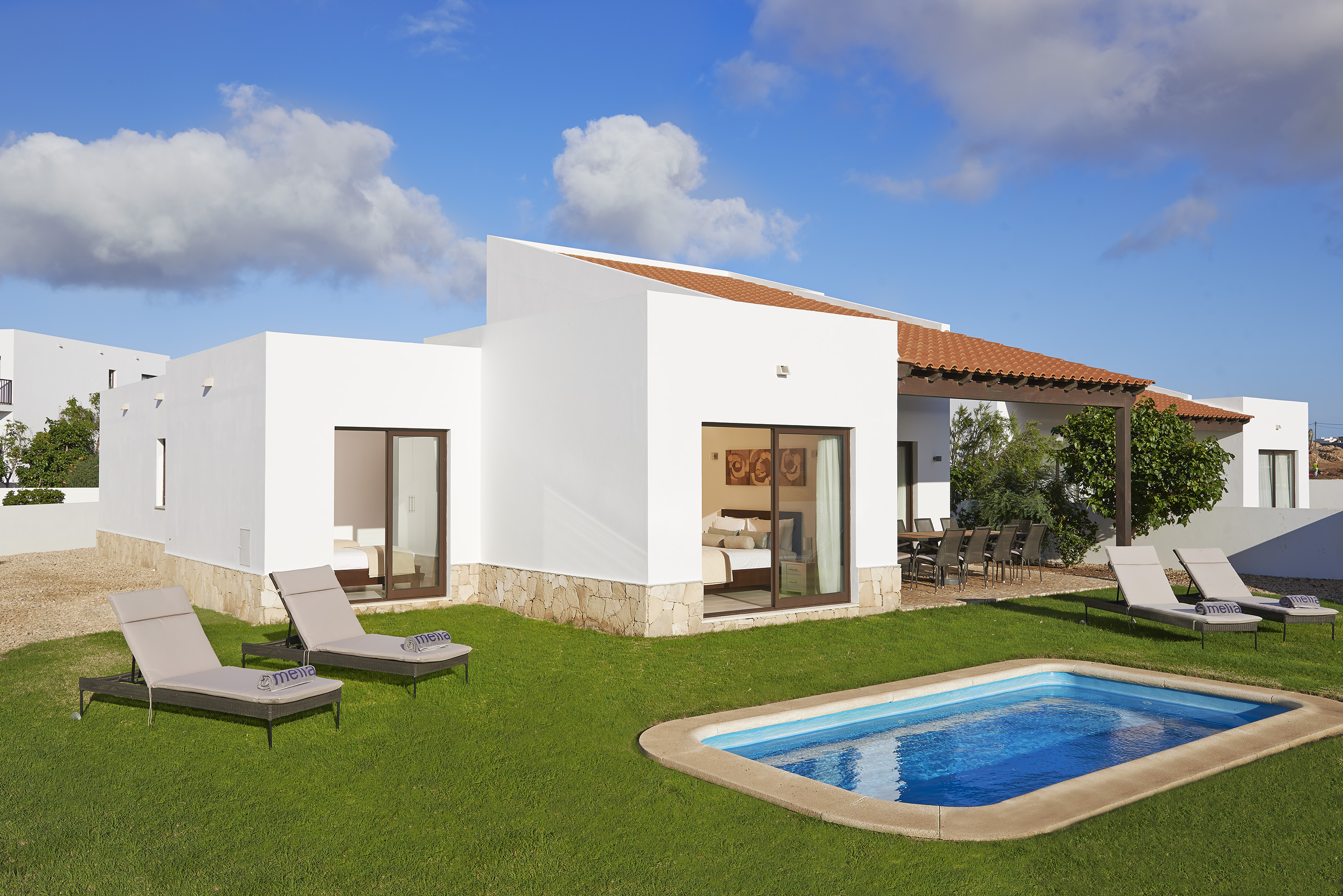 a pool in the grass next to a house
