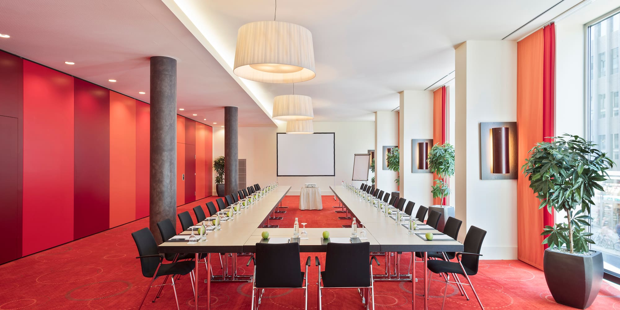 a long conference room with red carpet and white walls
