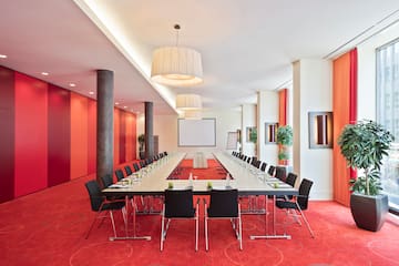 a long conference room with red carpet and white walls