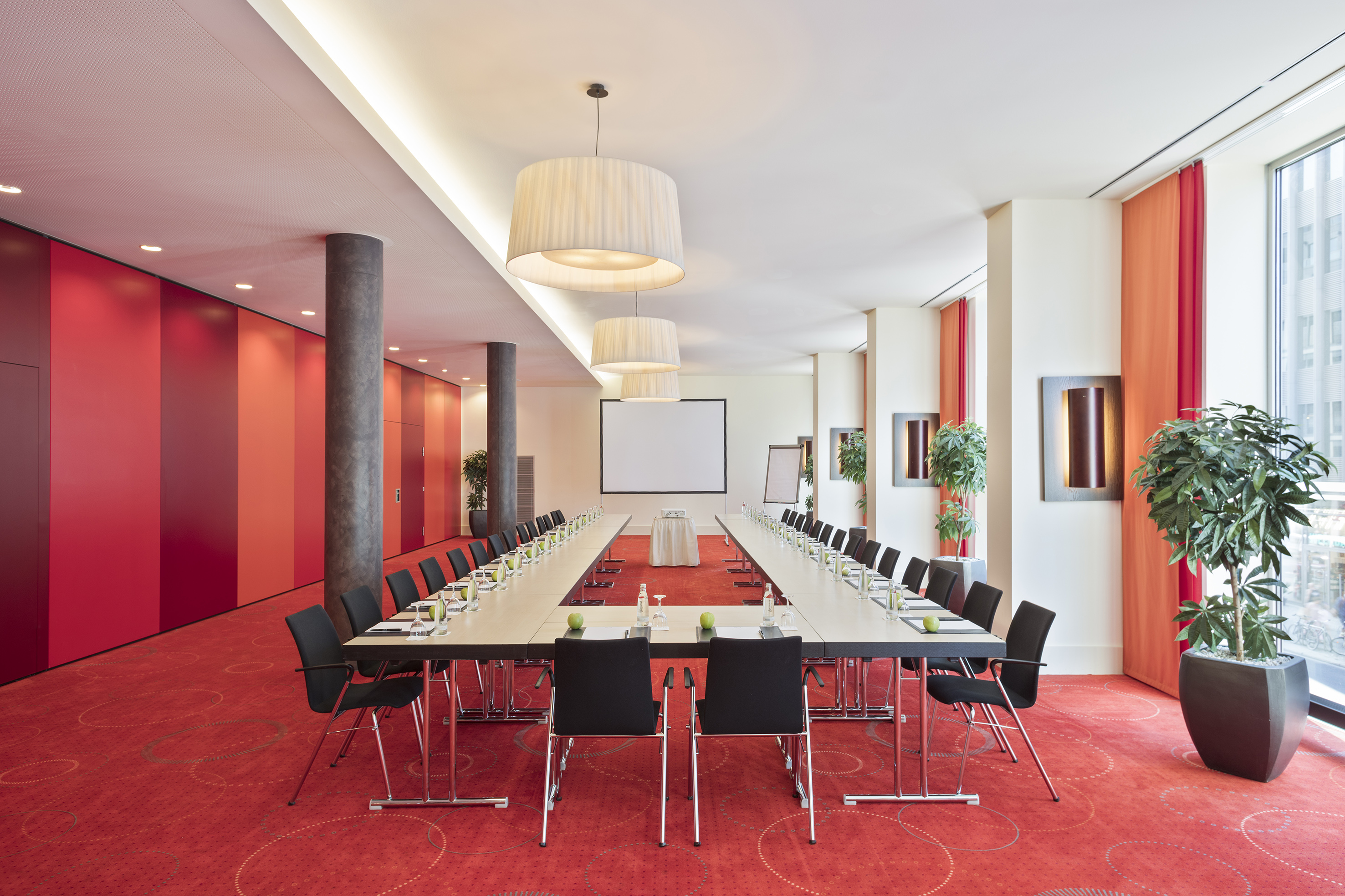 a long conference room with red carpet and white walls