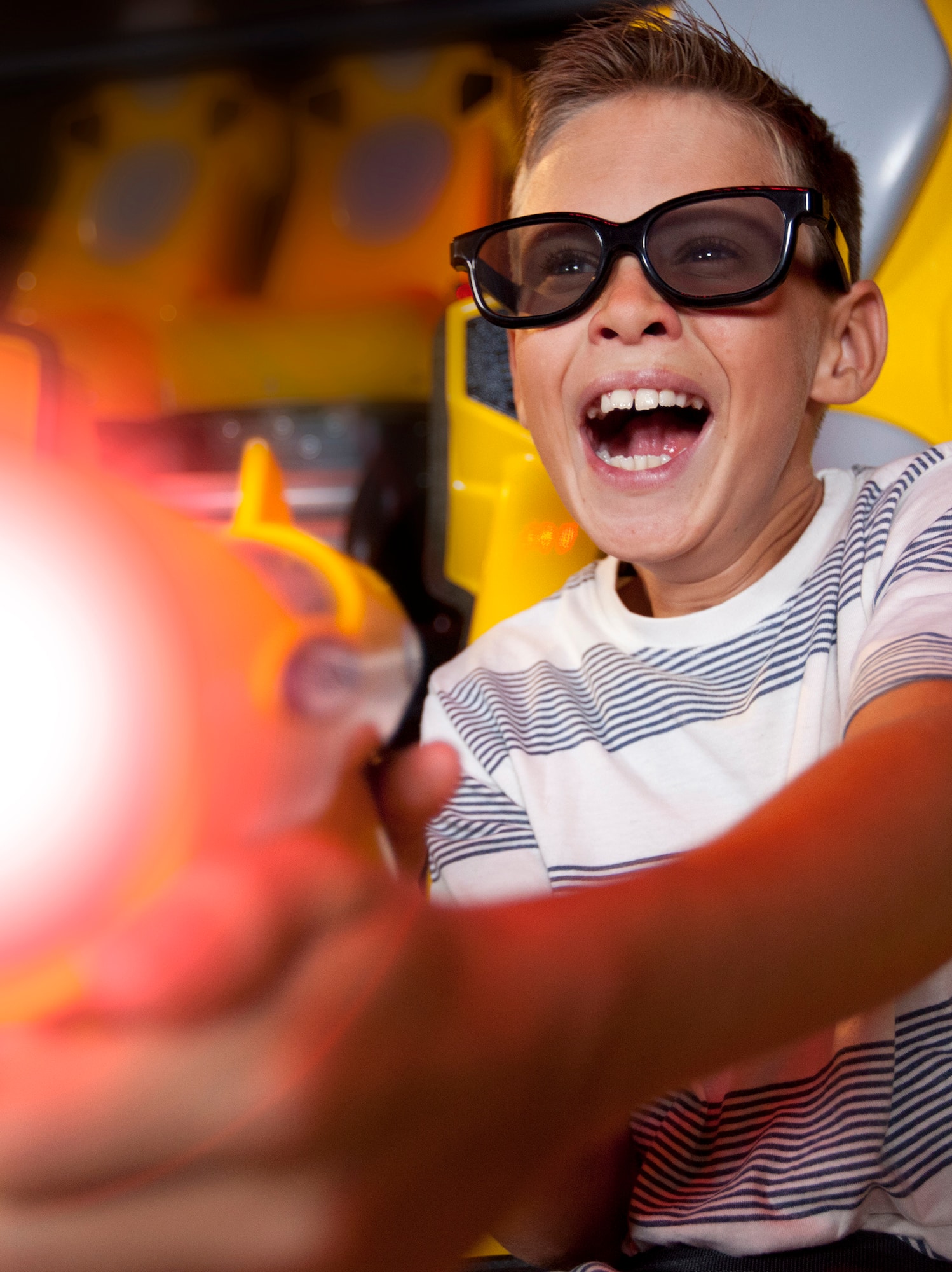 a boy wearing sunglasses and pointing a toy gun