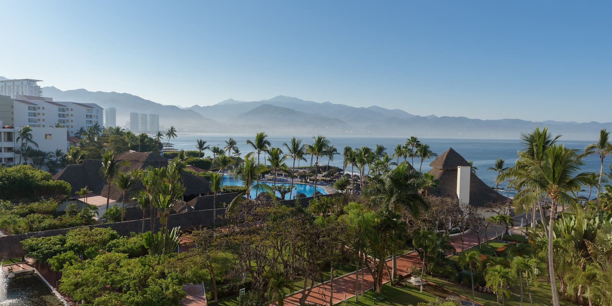 a resort with a pool and mountains in the background
