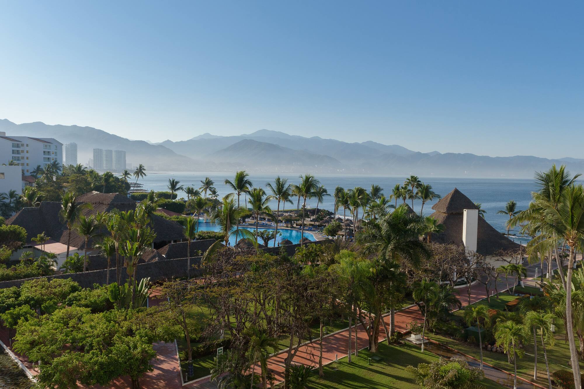 a resort with a pool and mountains in the background