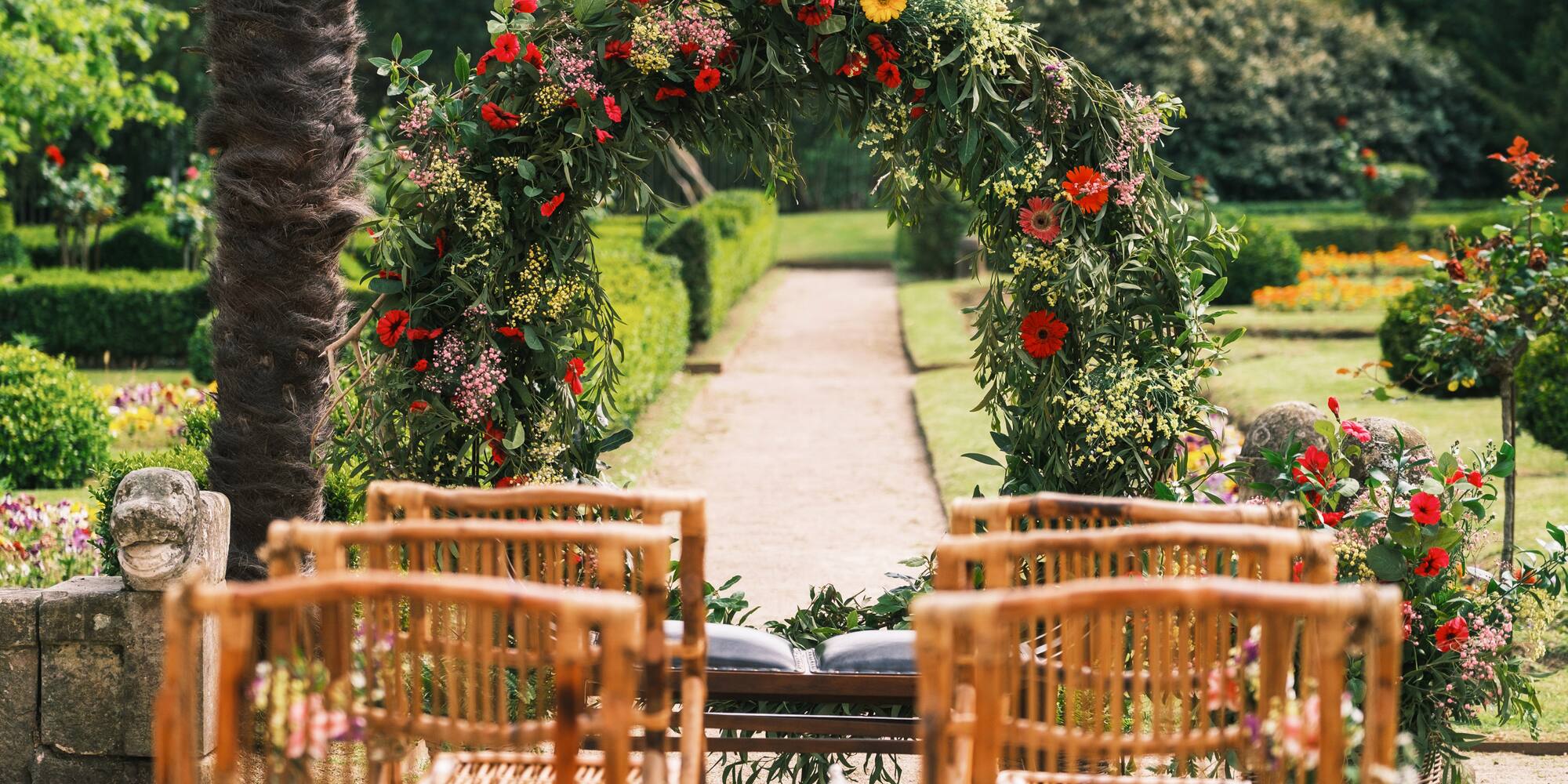 a flower arch with chairs in the background