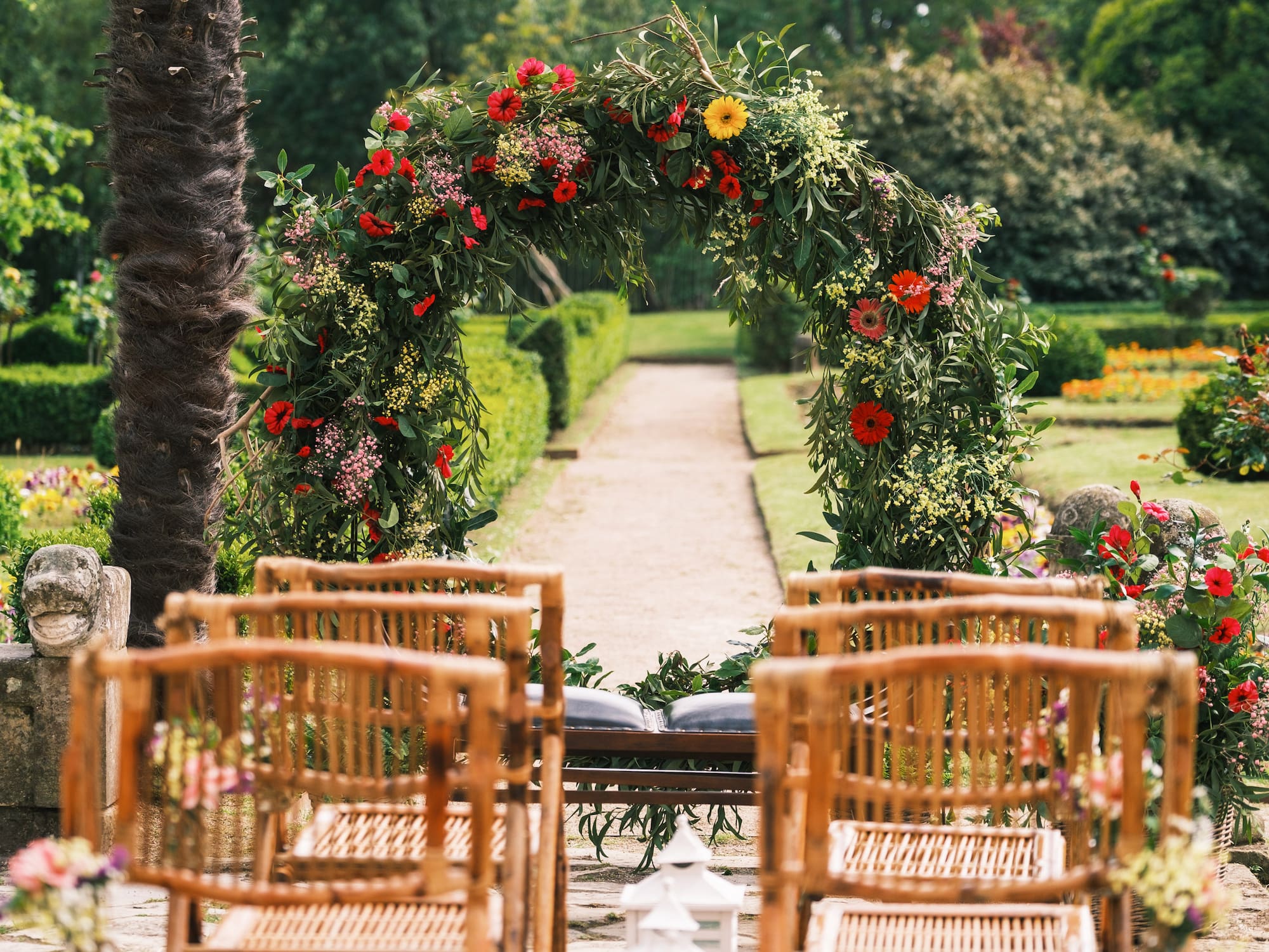a flower arch with chairs in the background