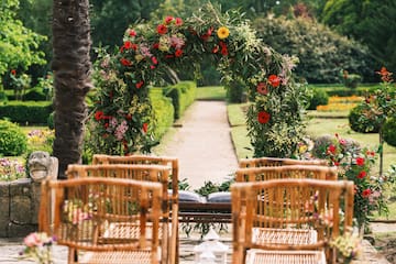 a flower arch with chairs in the background