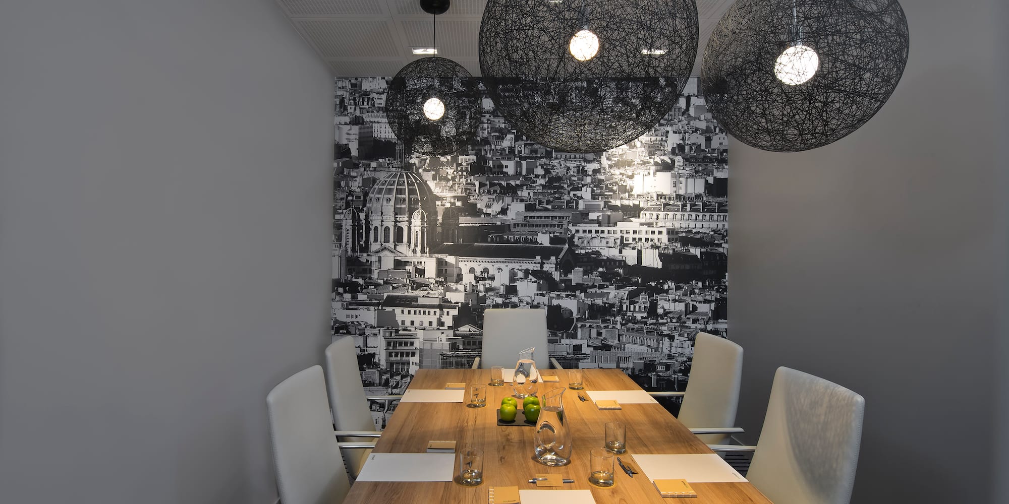 a table with chairs and lights from the ceiling