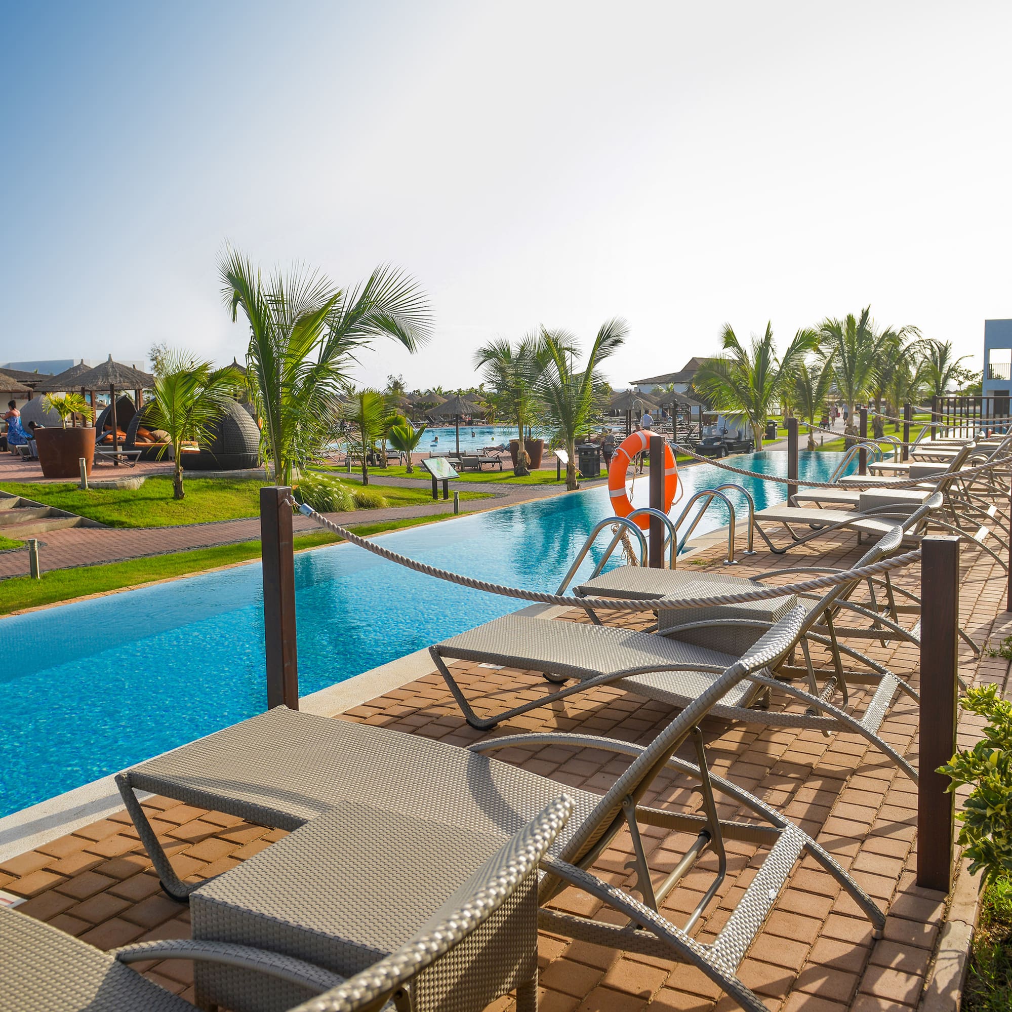 a pool with lounge chairs and a pool in the background