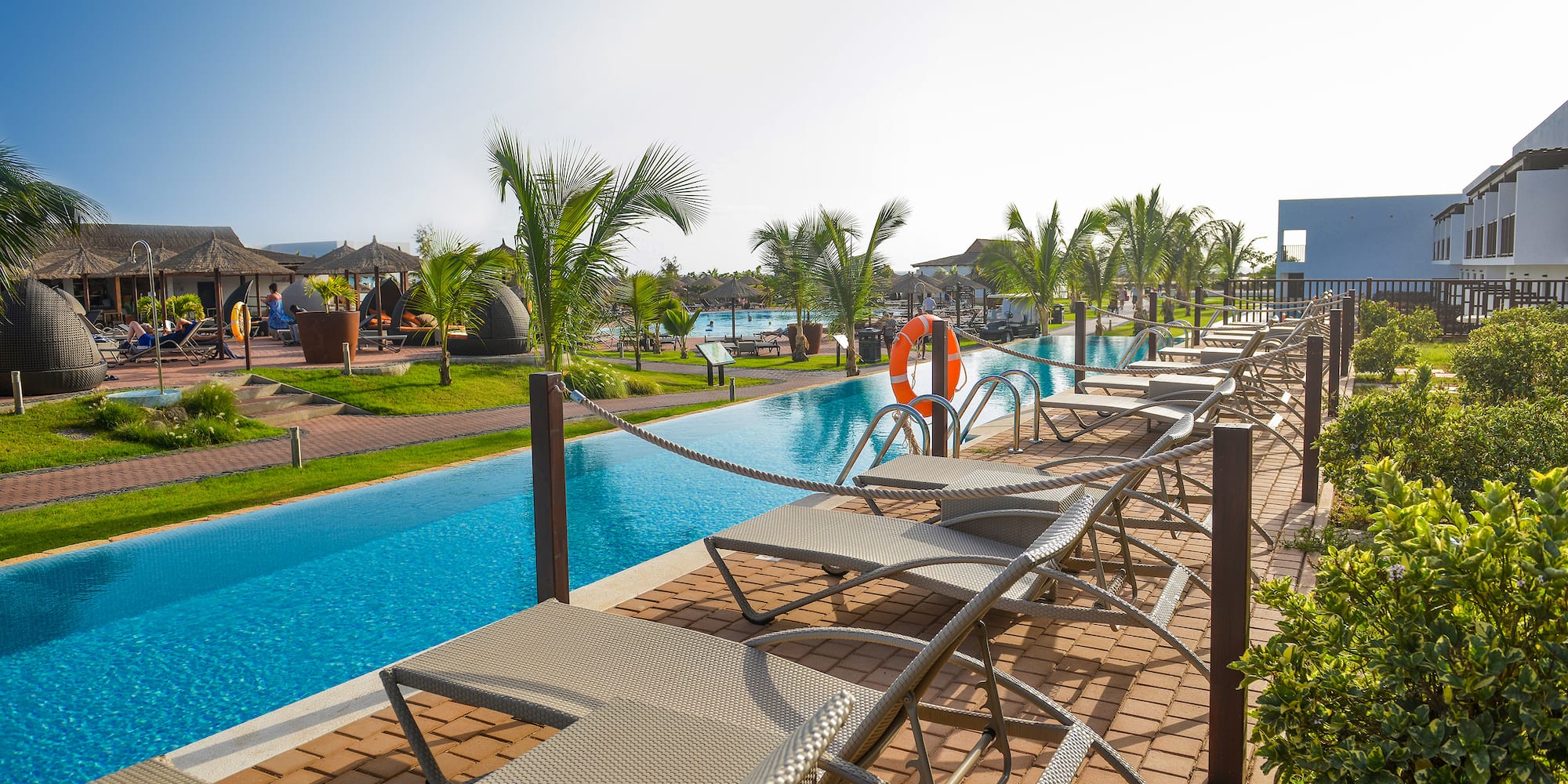 a pool with lounge chairs and a pool in the background