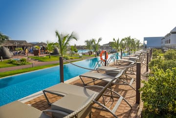 a pool with lounge chairs and a pool in the background