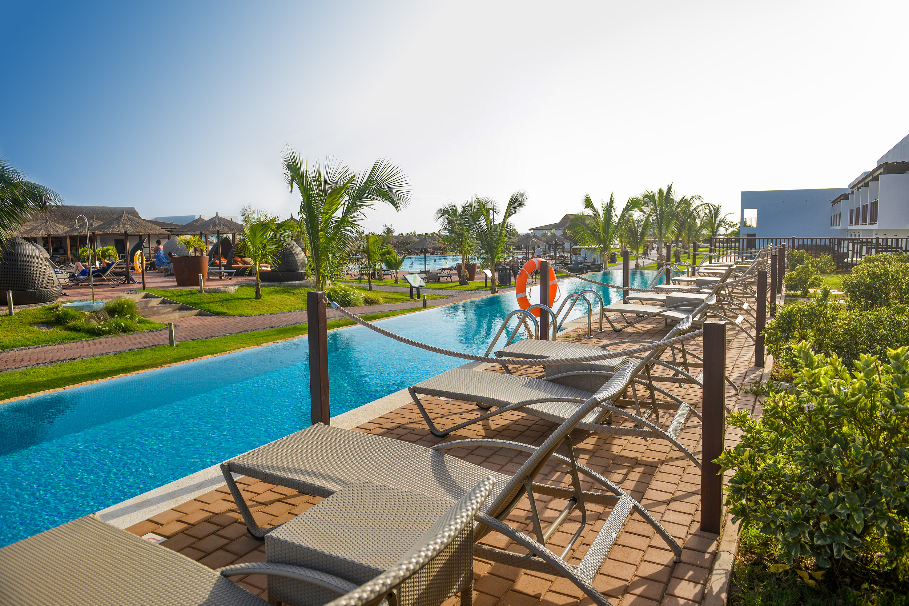 a pool with lounge chairs and a pool in the background