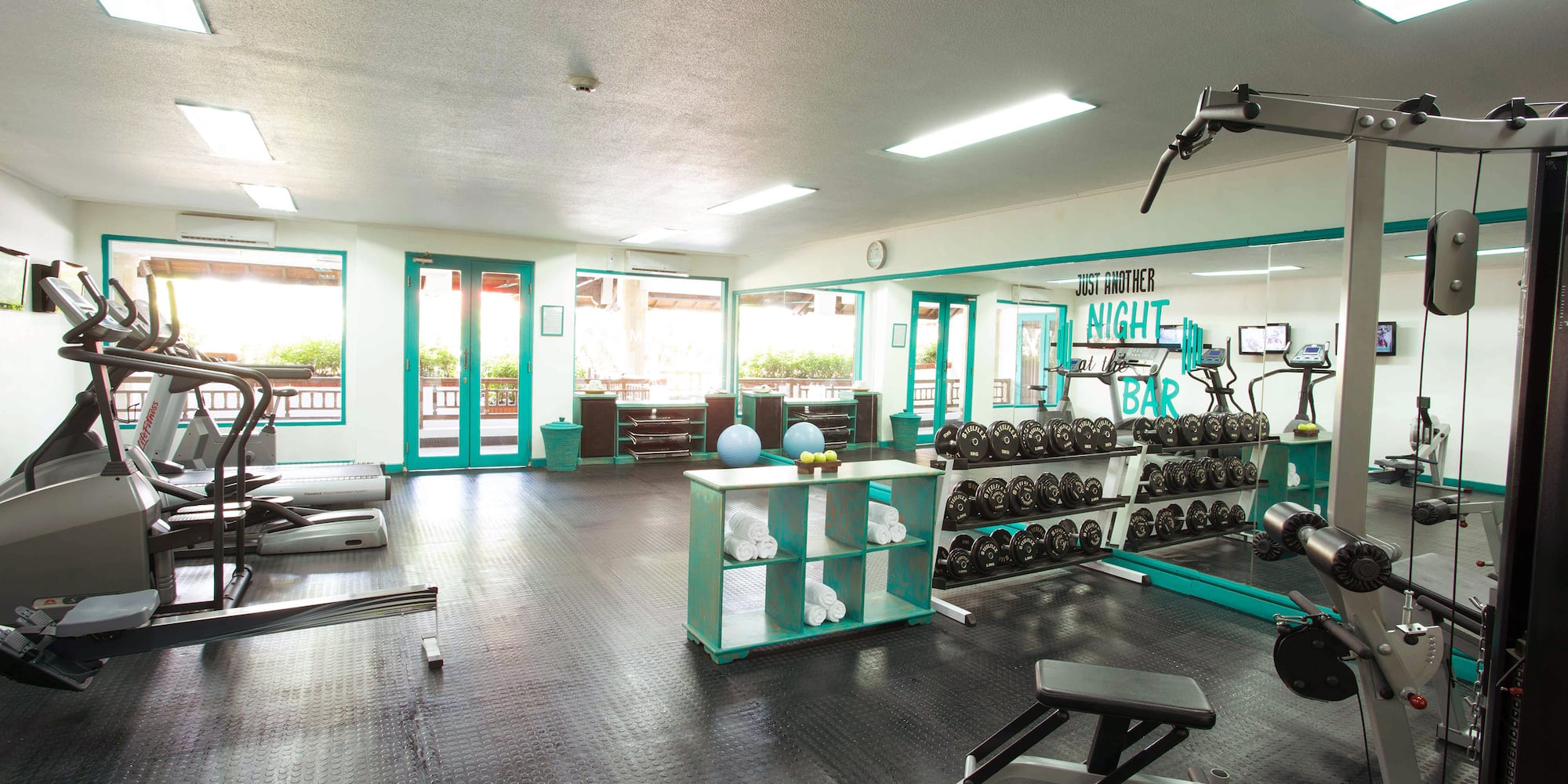 a room with exercise equipment and a shelf with weights