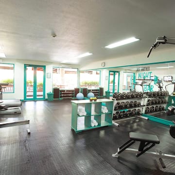 a room with exercise equipment and a shelf with weights