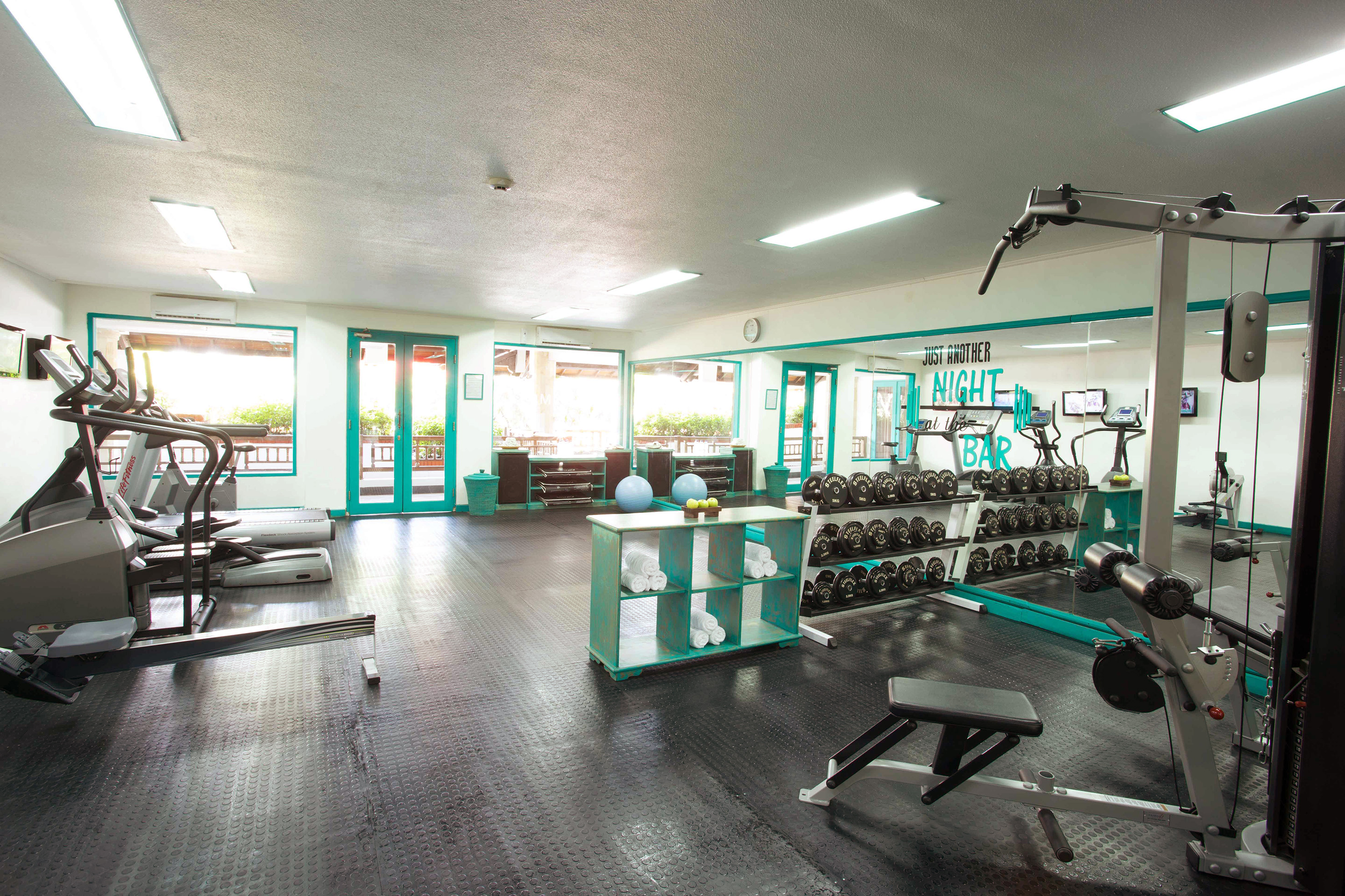 a room with exercise equipment and a shelf with weights