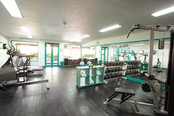 a room with exercise equipment and a shelf with weights