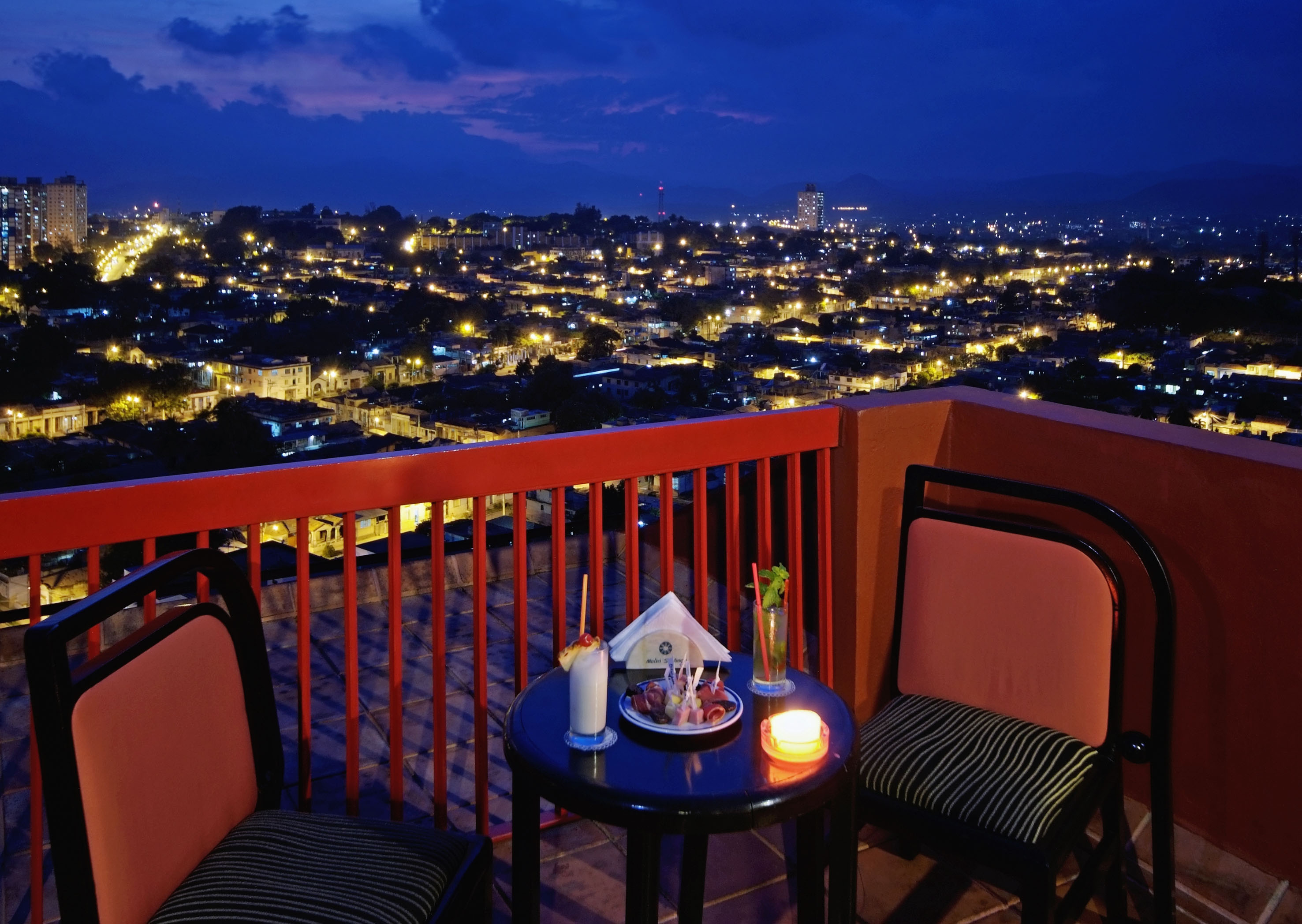 a table and chairs on a balcony overlooking a city
