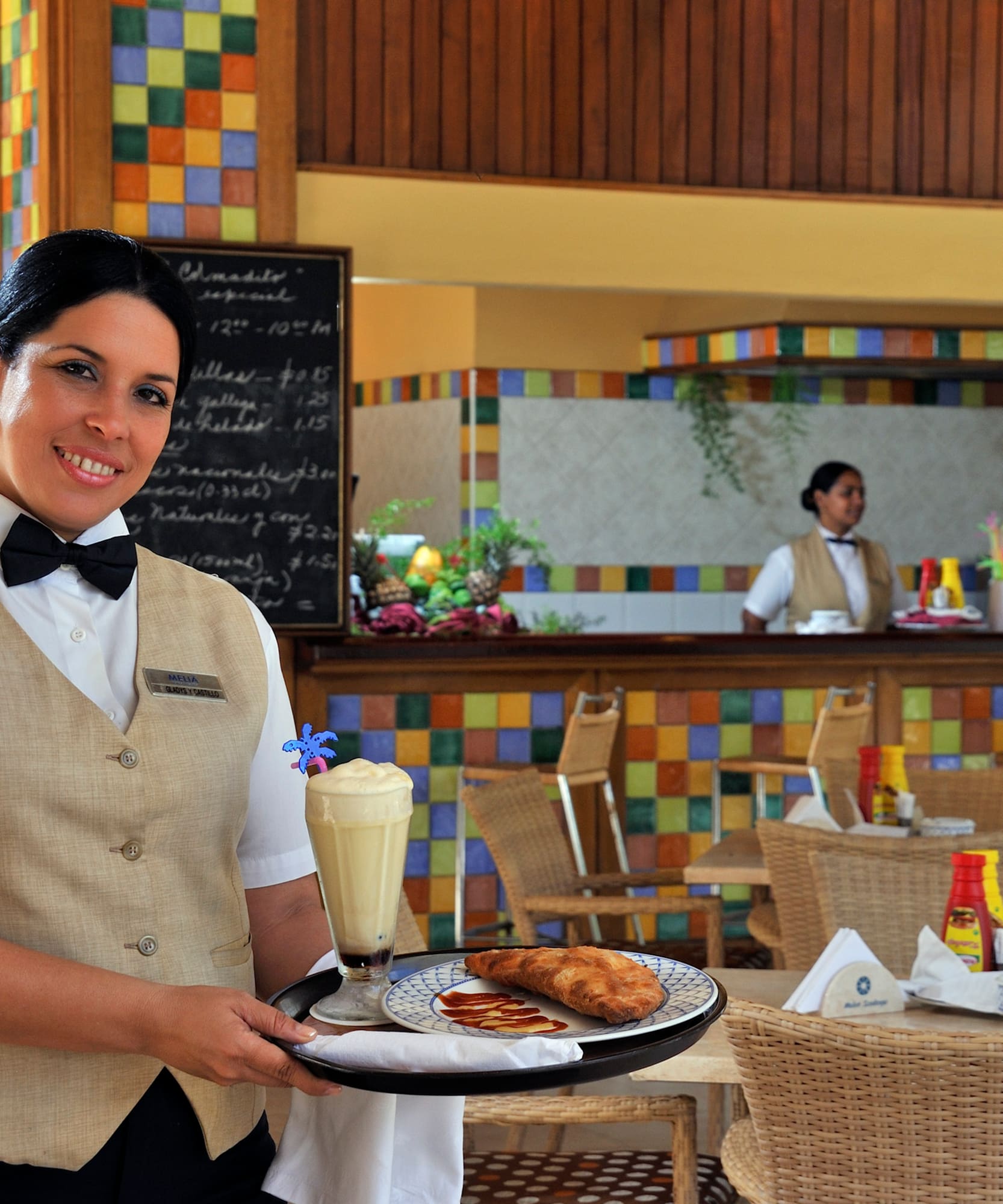 a woman holding a tray with food and drinks