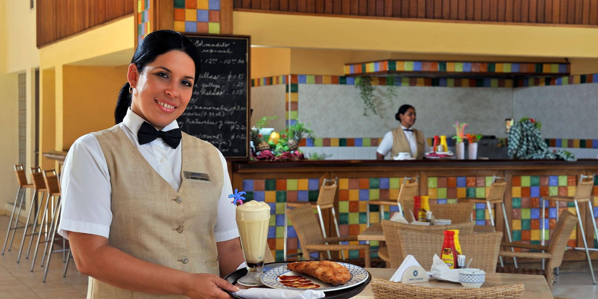 a woman holding a tray with food and drinks