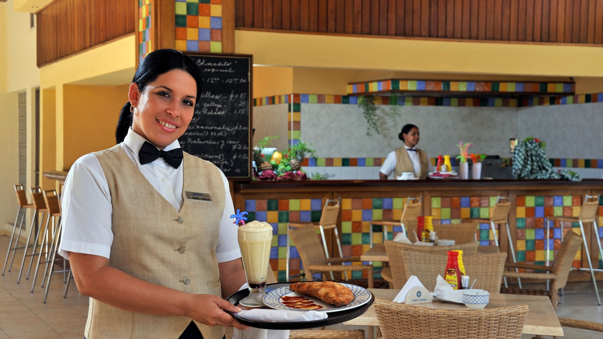 a woman holding a tray with food and drinks