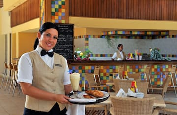 a woman holding a tray with food and drinks