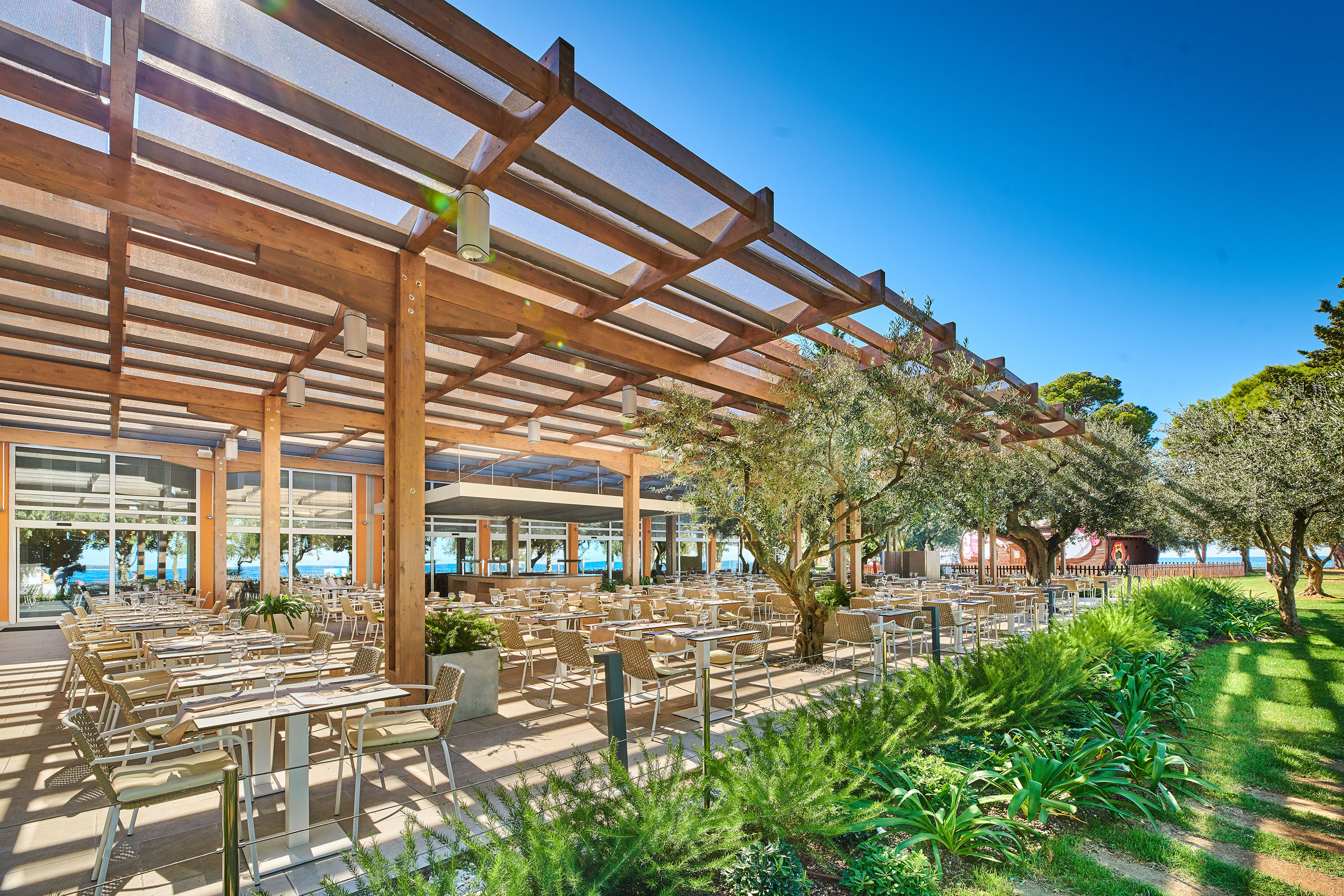 a covered patio with tables and chairs