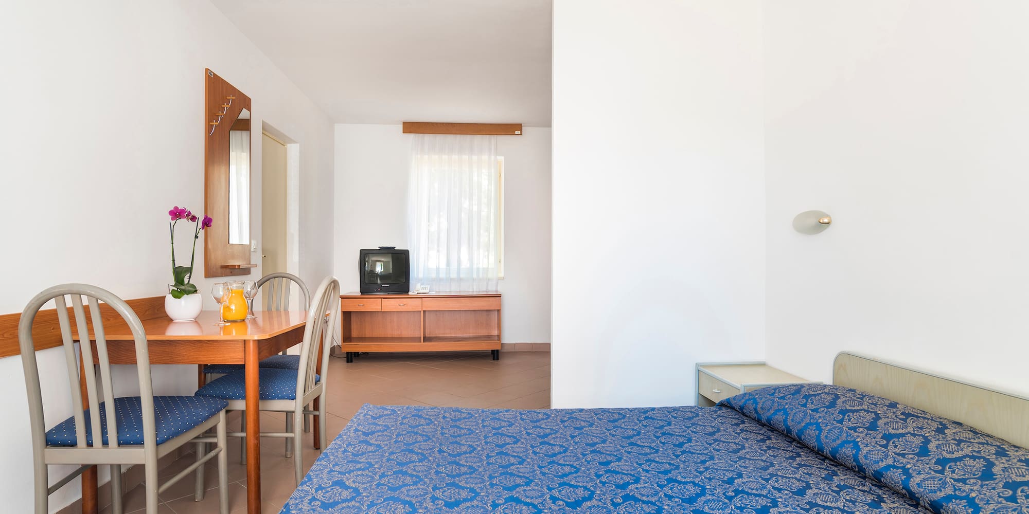 a room with a bed and a television