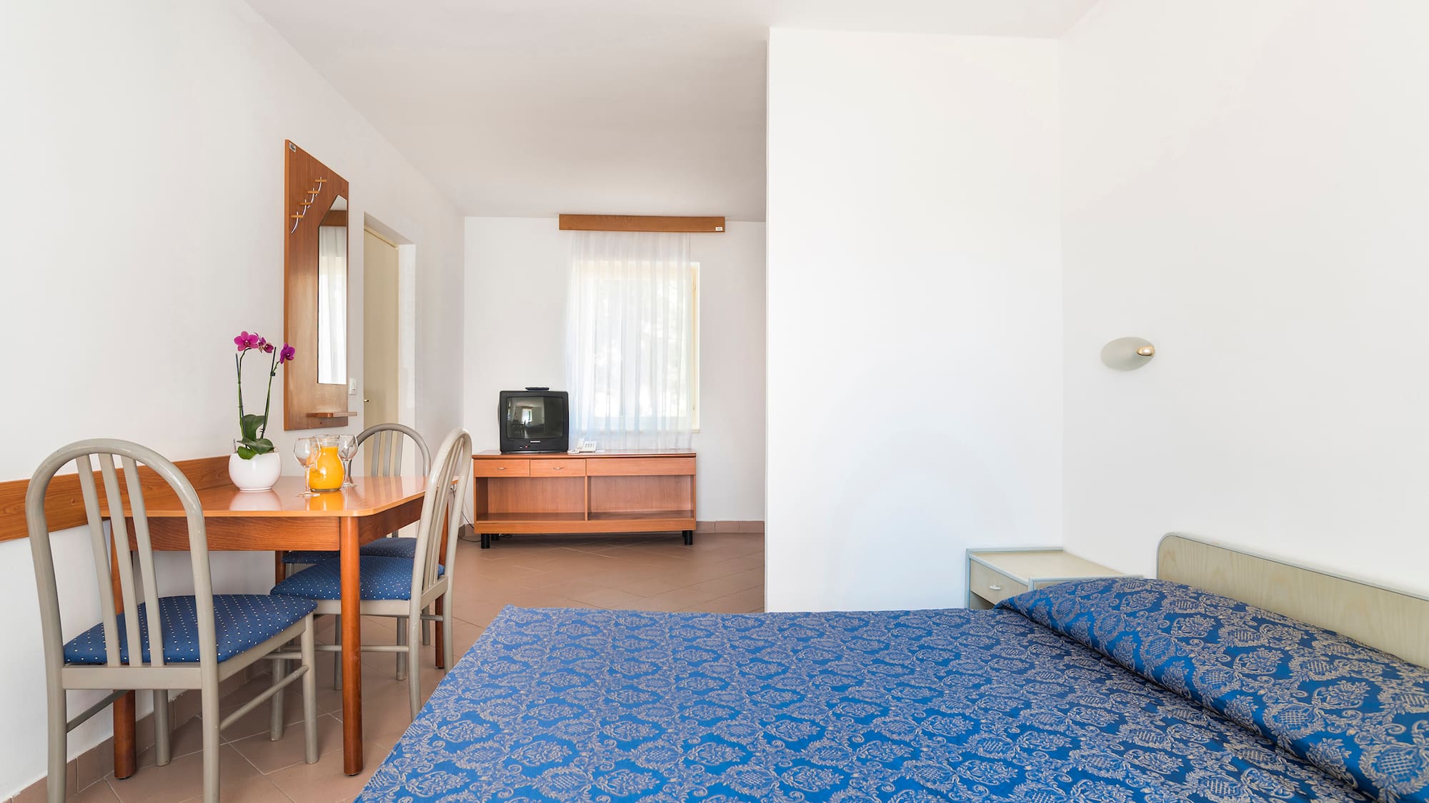 a room with a bed and a television