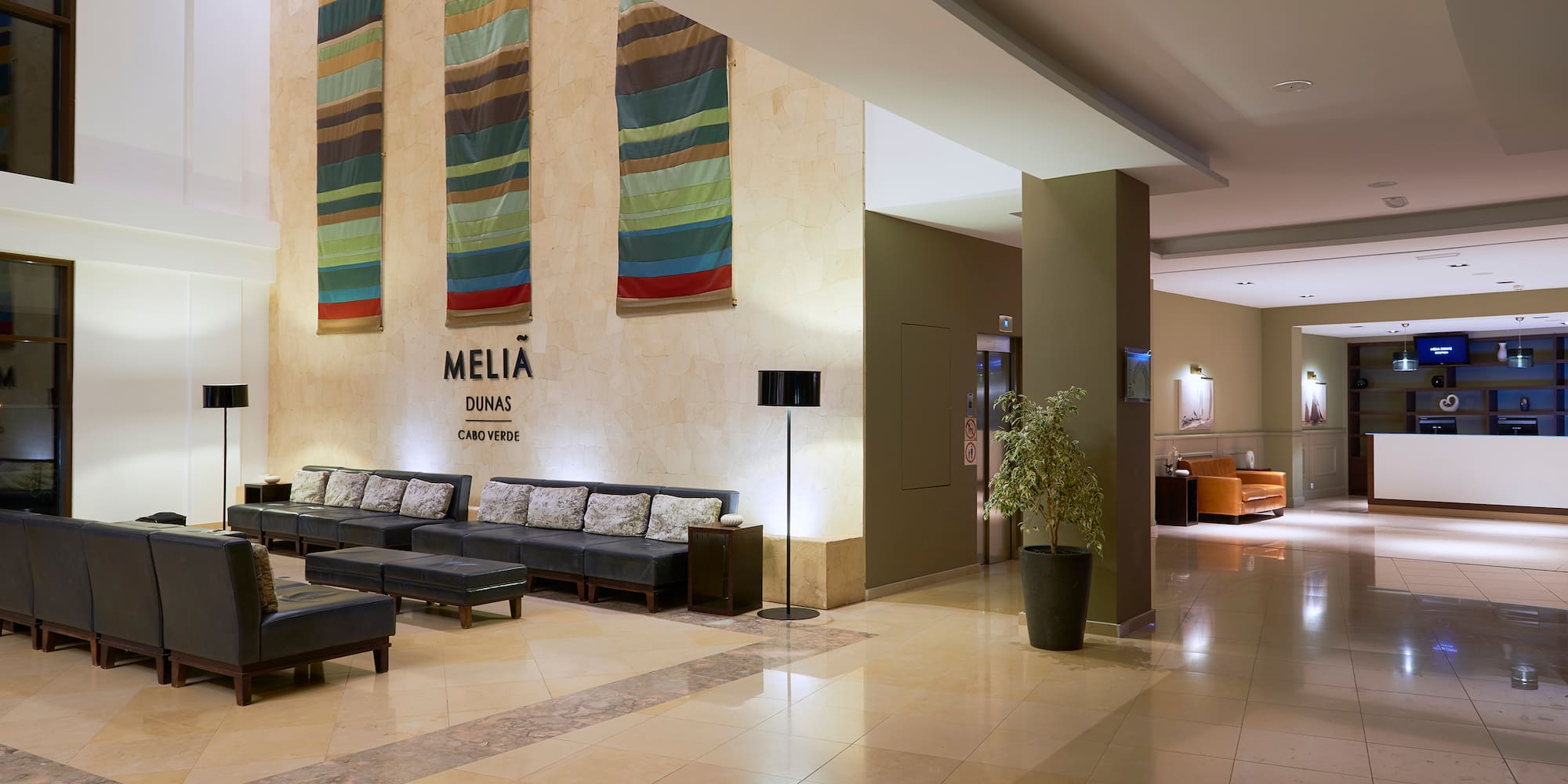 a lobby with chairs and a plant