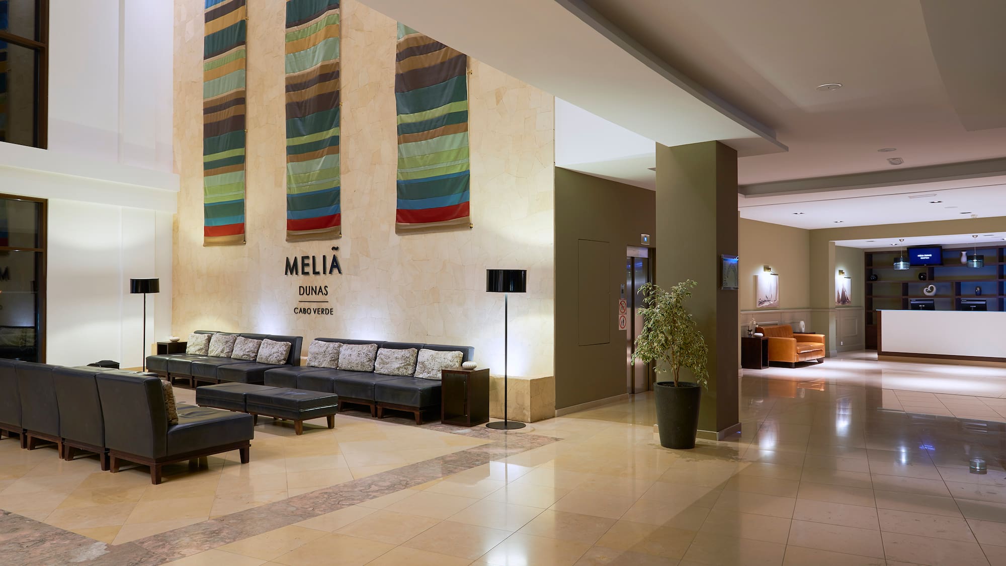 a lobby with chairs and a plant