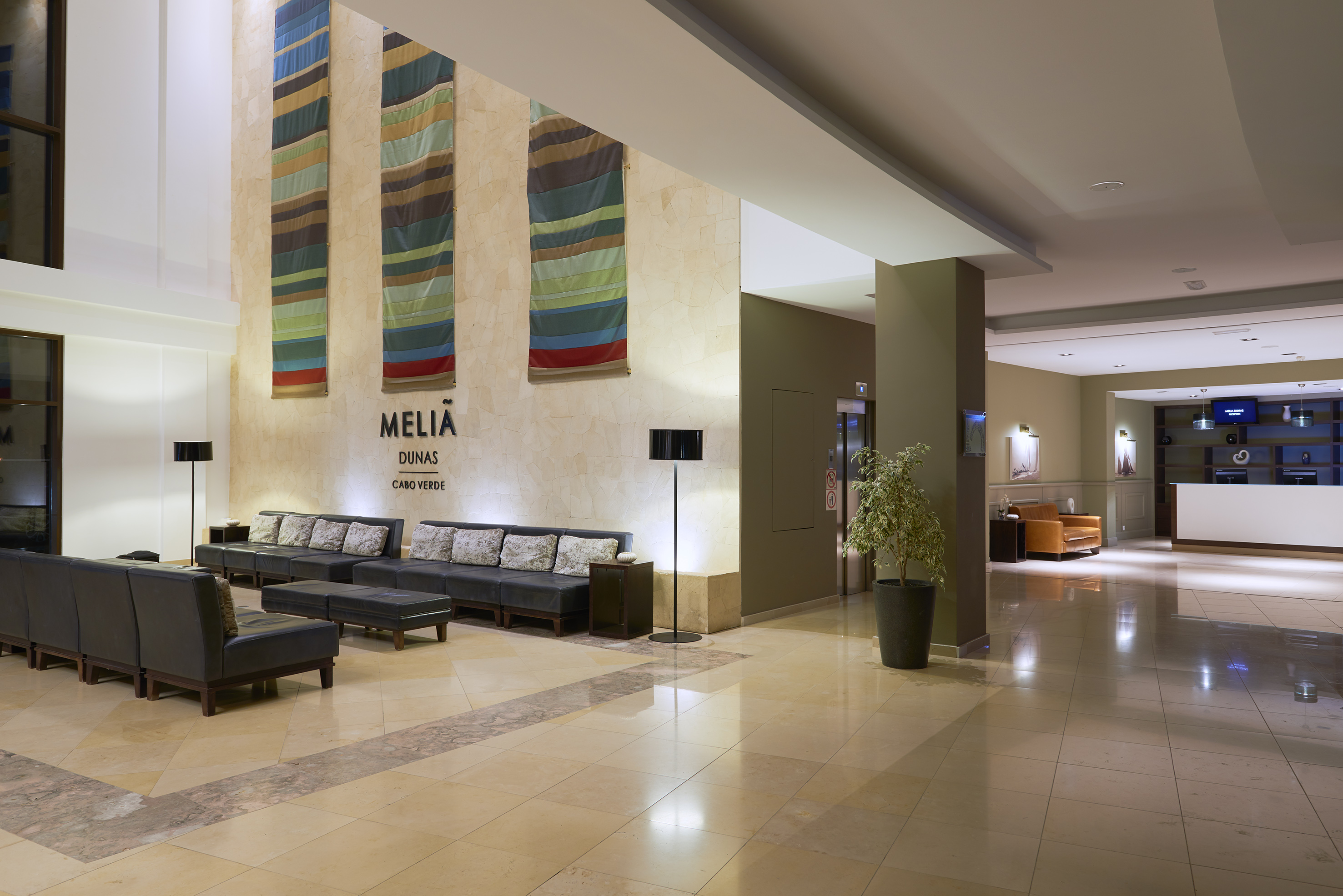 a lobby with chairs and a plant