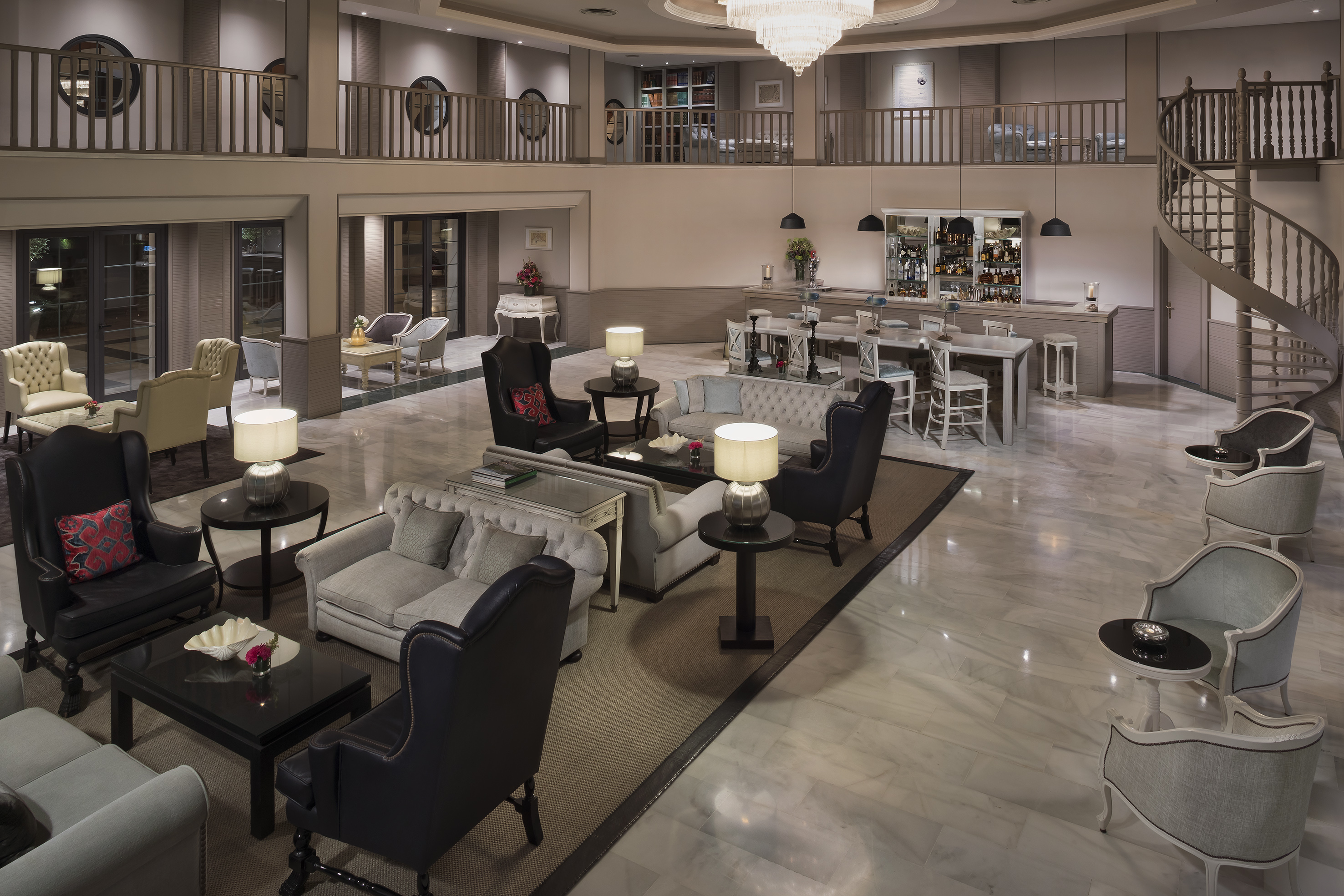 Luxurious hotel lobby lounge with elegant seating, a bar, and grand staircase.