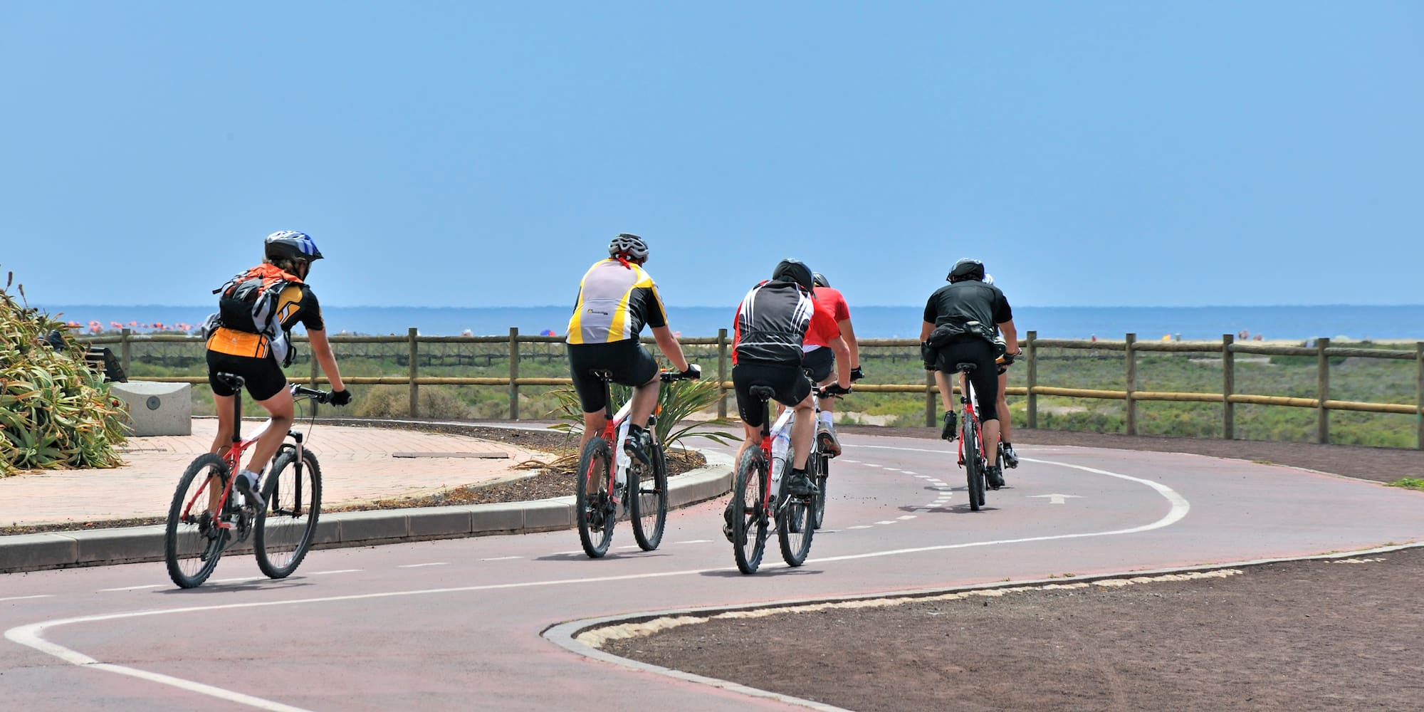 a group of people riding bicycles on a road