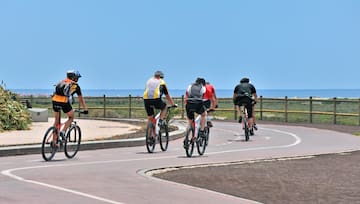 a group of people riding bicycles on a road