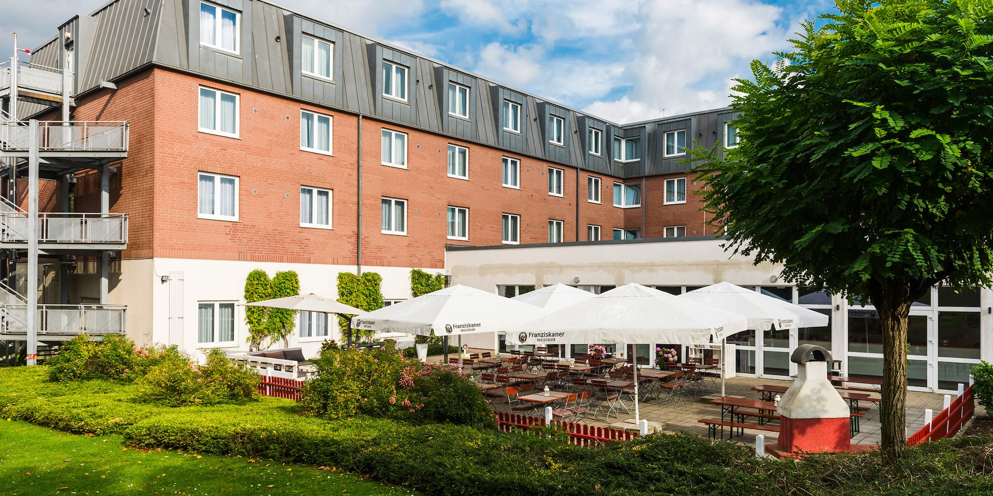 a building with a lawn and tables and chairs