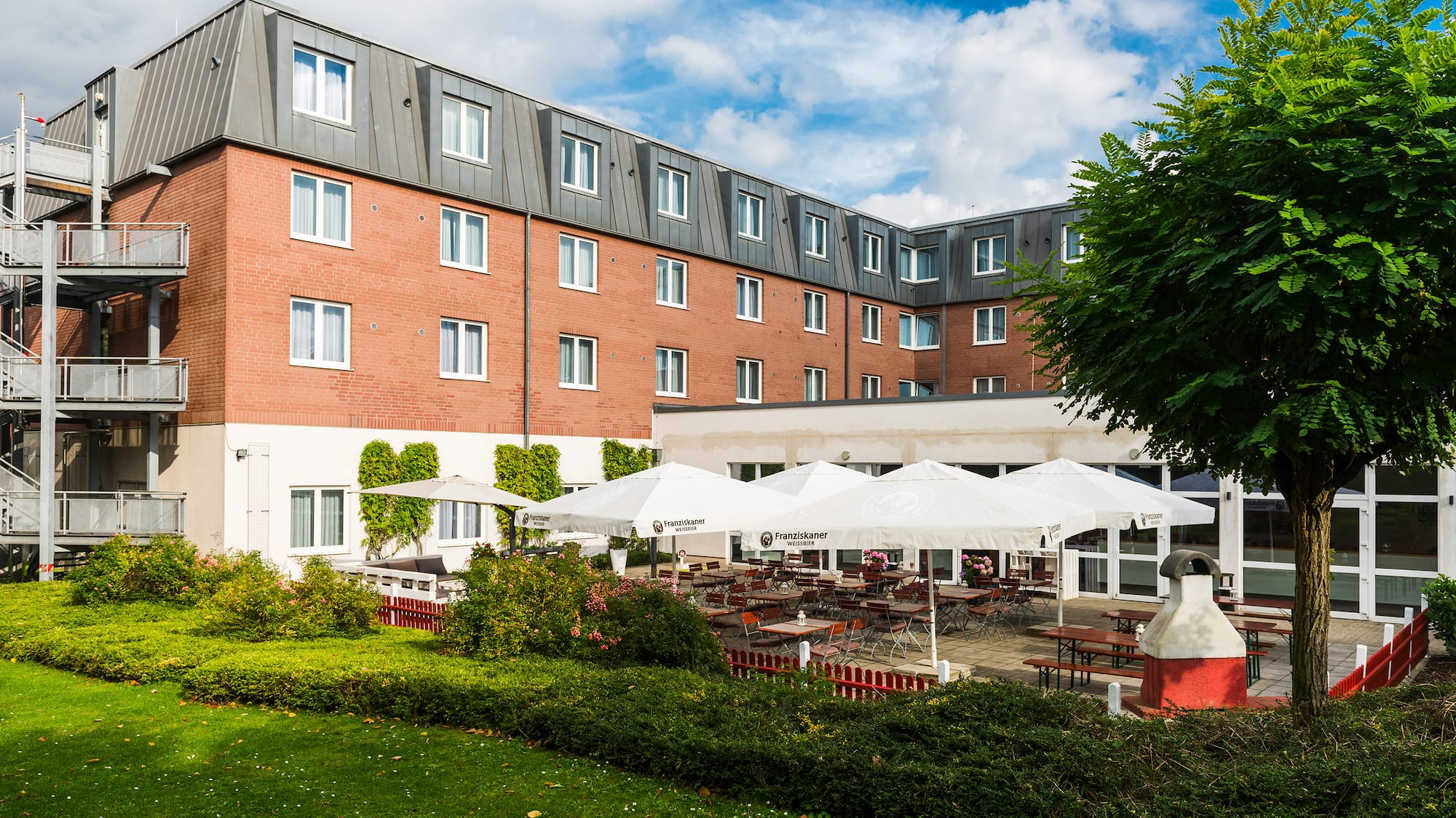 a building with a lawn and tables and chairs