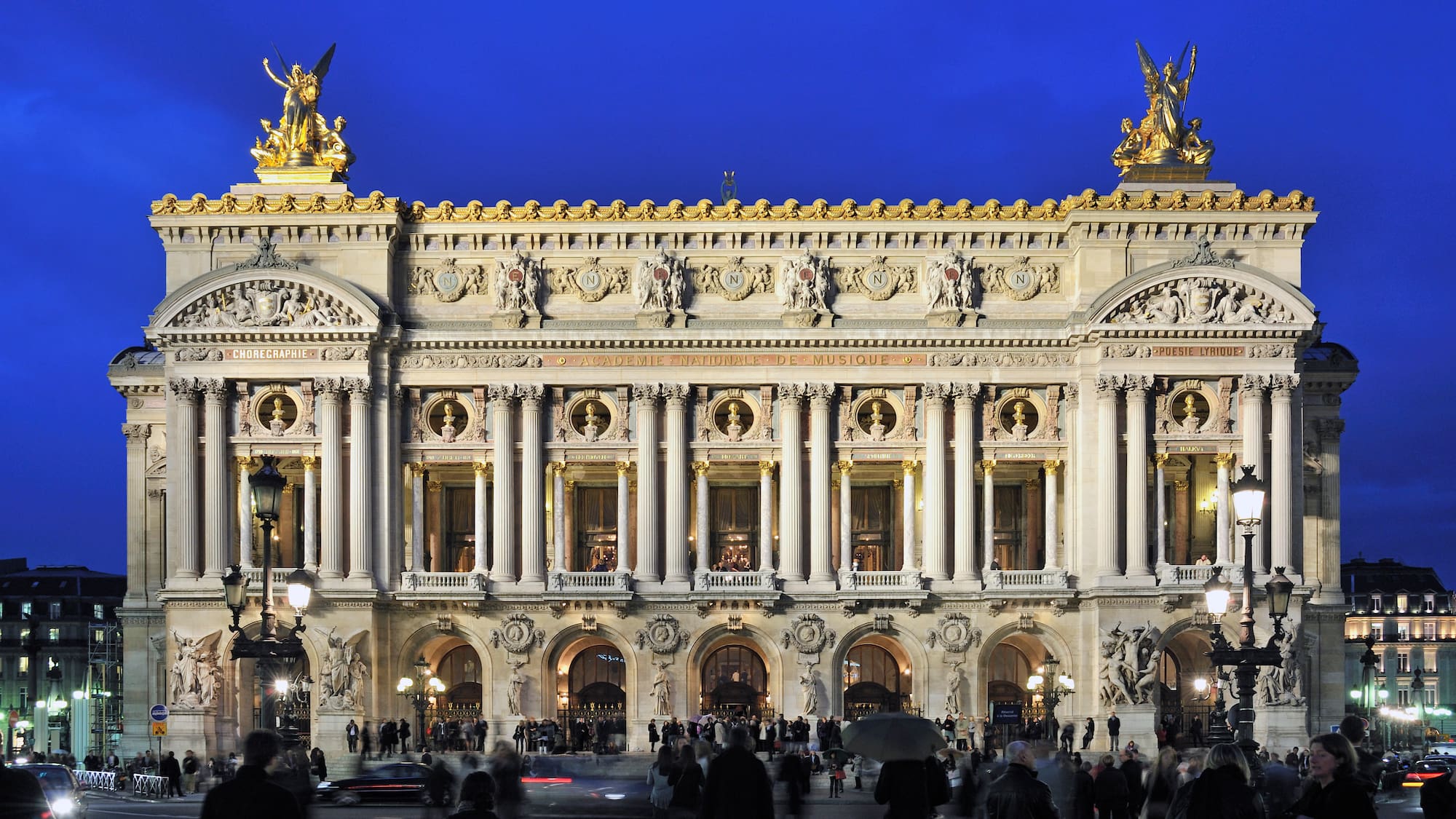 a large building with columns and statues with Palais Garnier in the background