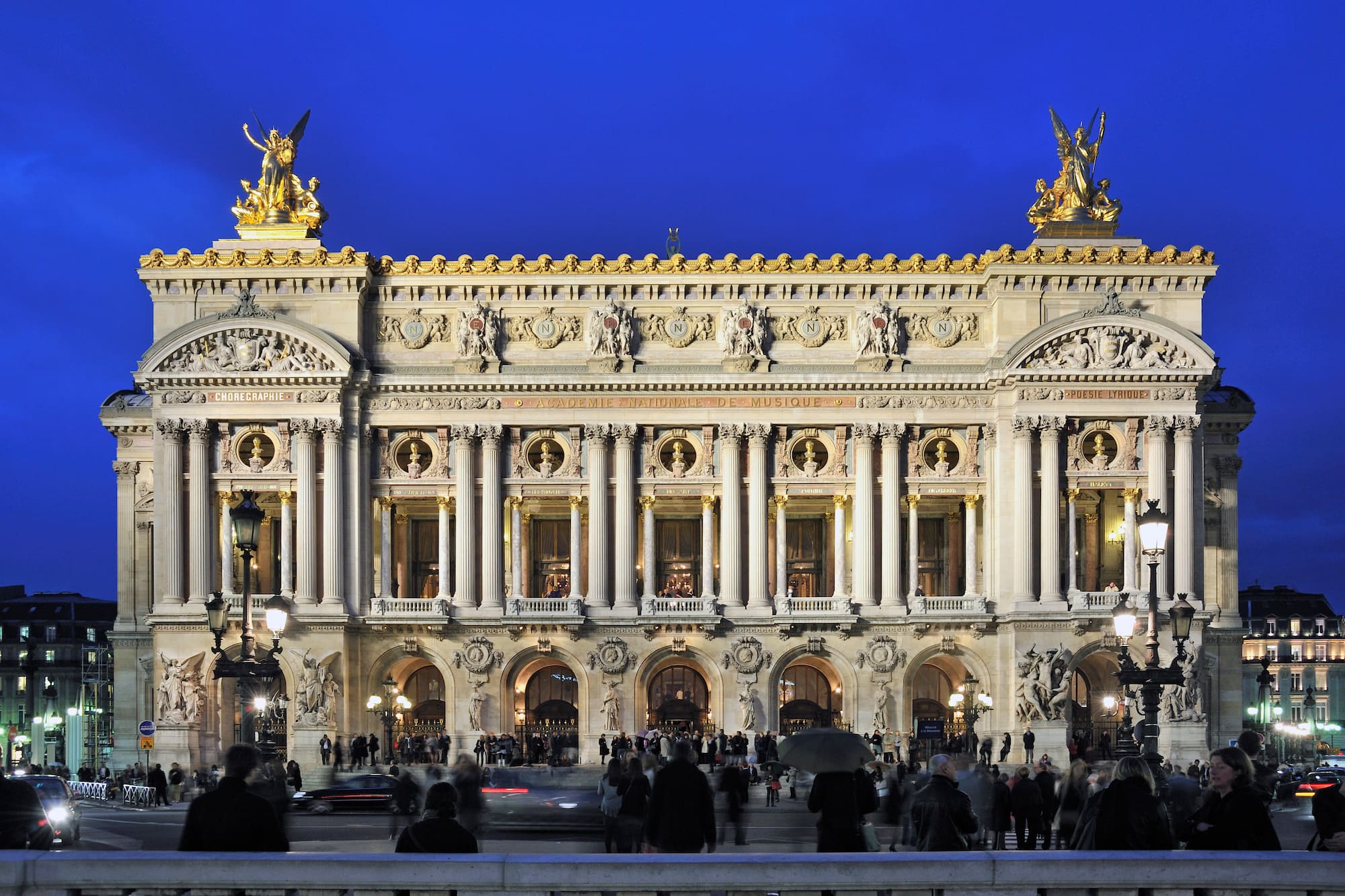 a large building with columns and statues with Palais Garnier in the background