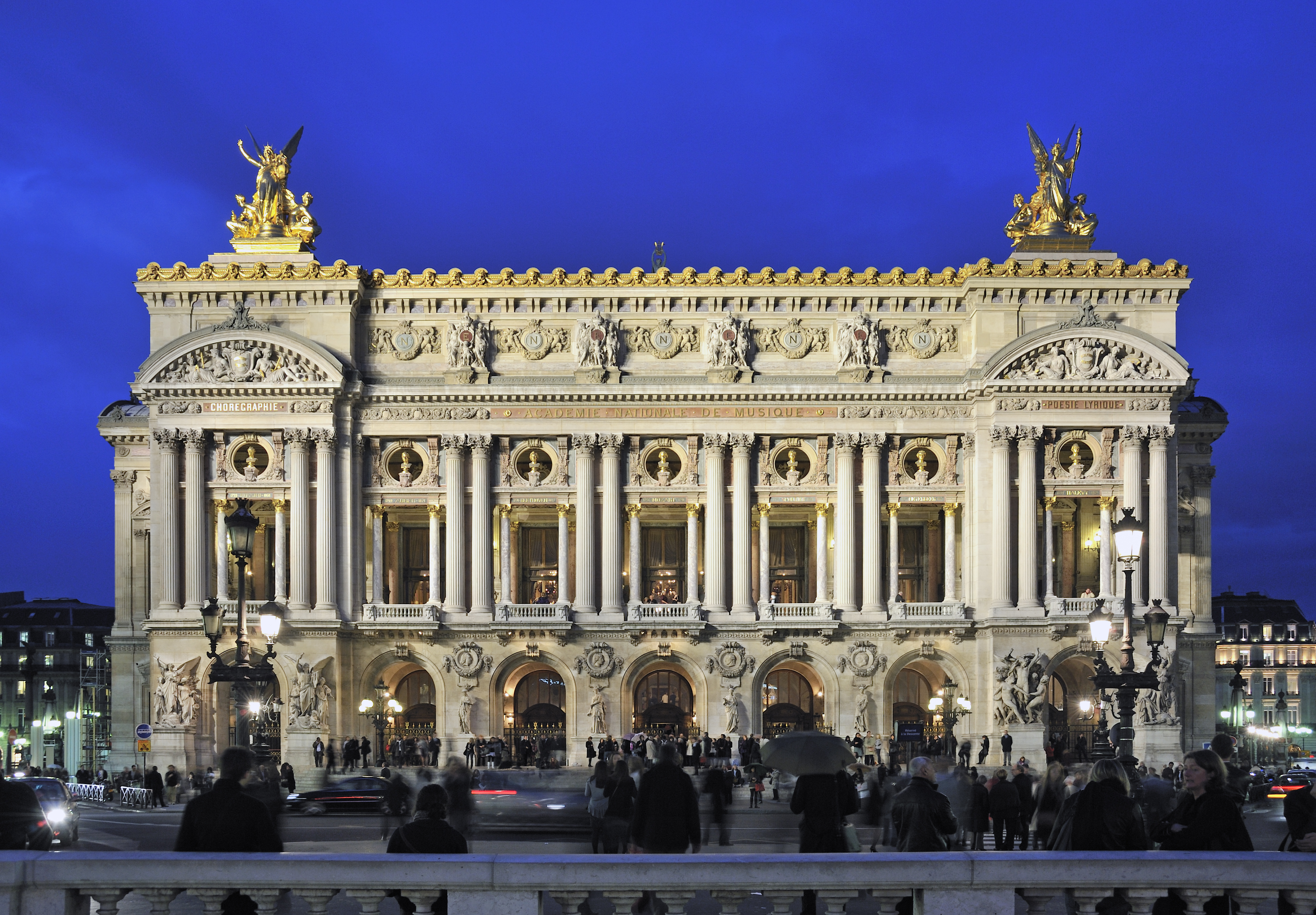a large building with columns and statues with Palais Garnier in the background