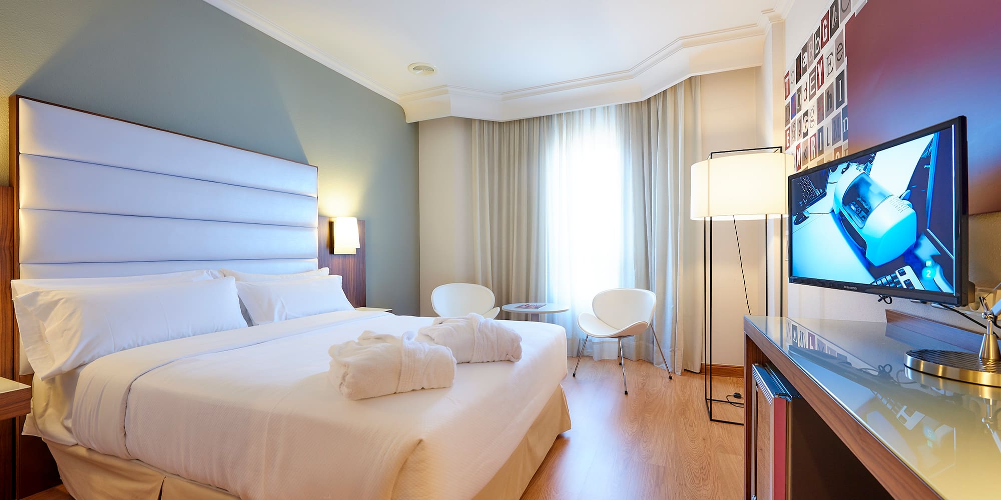 a bedroom with a bed and a television